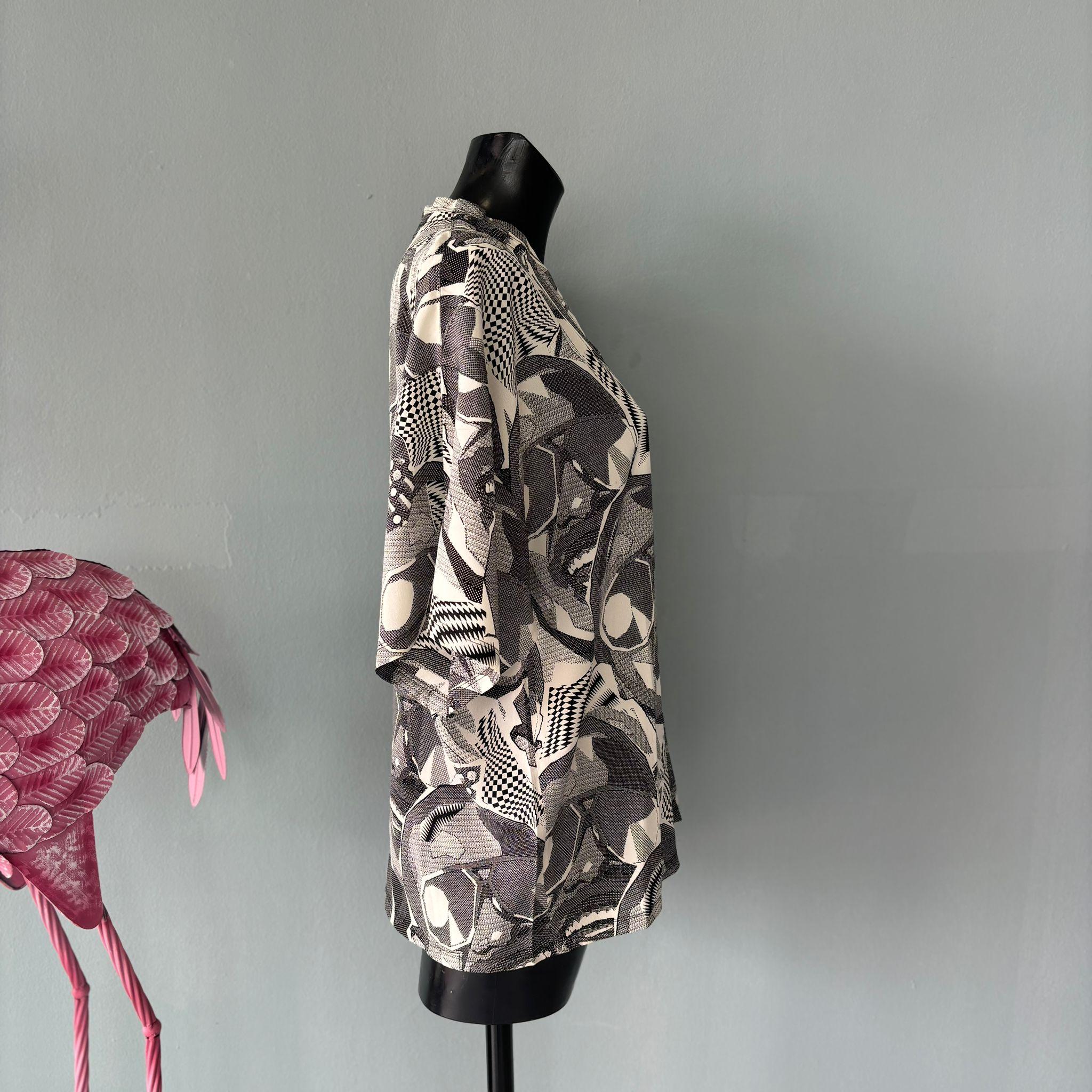 maglia in seta Gianni Versace per Genny bianca e nera optical con fantasia volti
Scollo a V, taglio morbido, spalla raglan che si adatta a diverse taglie
Condizioni ottime
Misure:
Lunghezza 73 cm
Petto 59 cm
