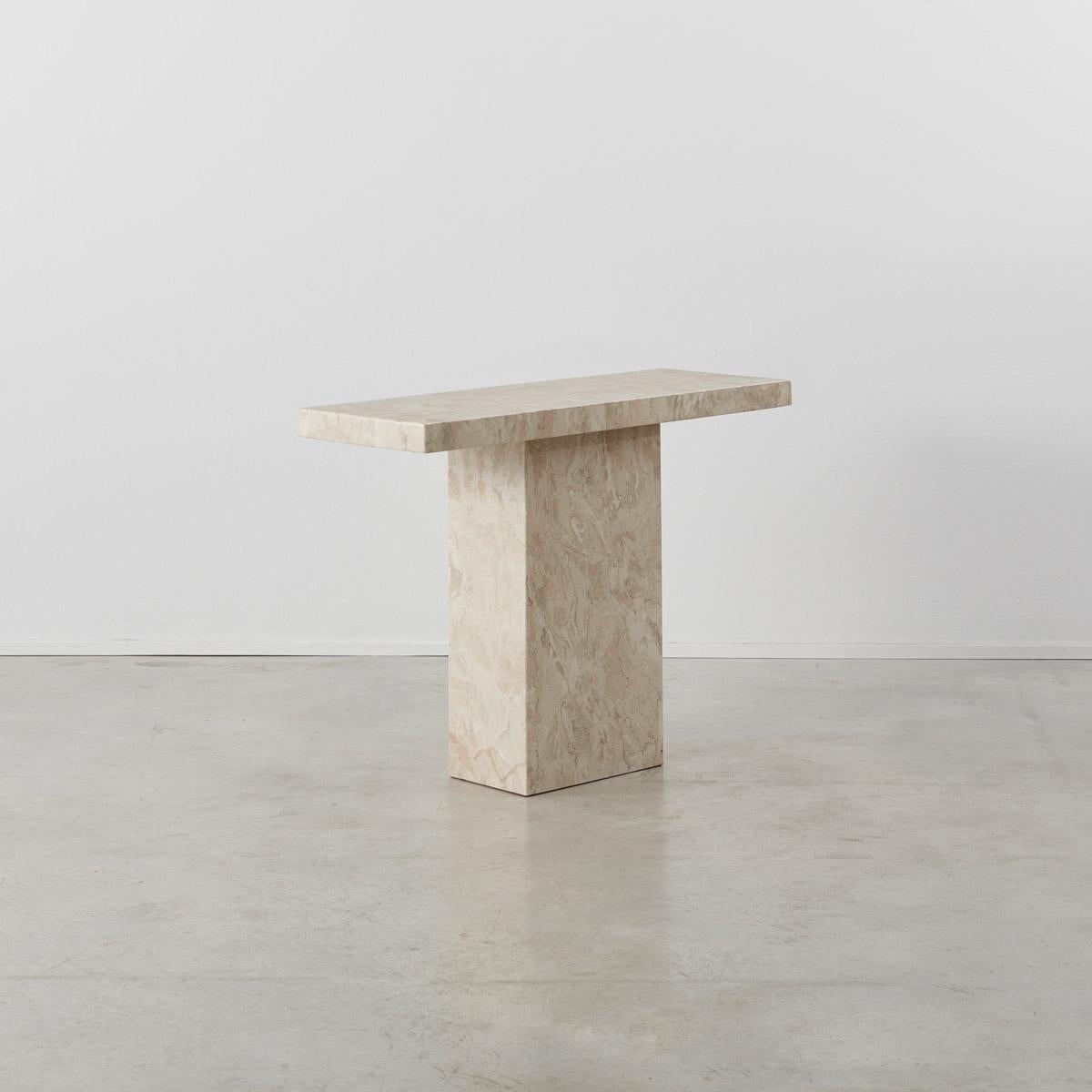 This nicely proportioned console table is made from polished blush marble stone. The marble has a lovely variation of dark, pale pinks and natural tones that run throughout. The thick squared top simply rests on a hollow rectangular base. It is in