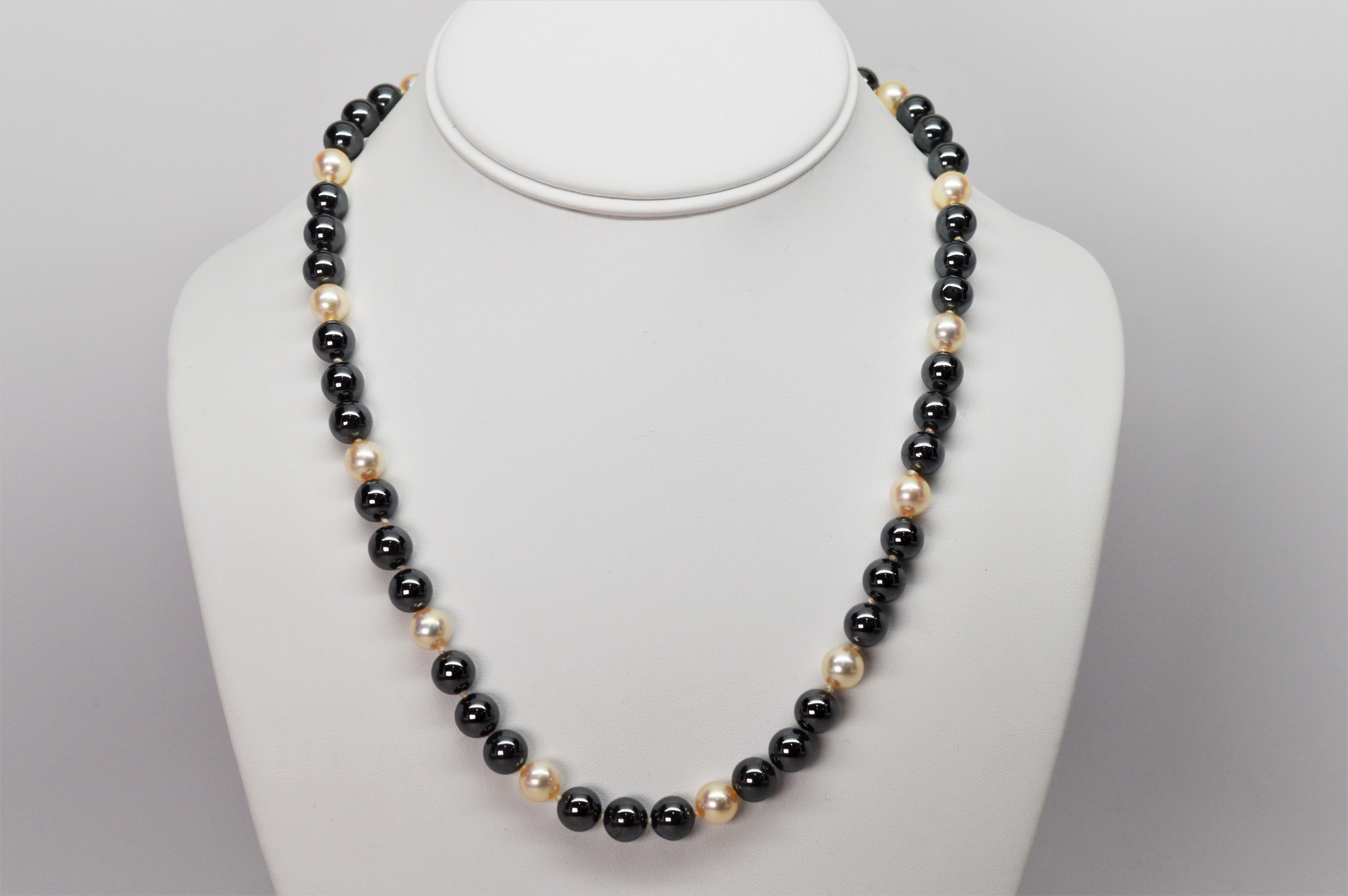 Pretty blush color round 8.5 mm AAA Akoya Pearls enhance the reflective slate gray Hematite beads that create this eighteen inch strand. Said to absorb negative energy and be calming, the hematite round stone beads measure 8mm. The necklace is