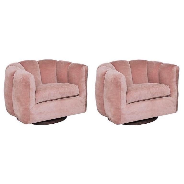 Glamourous and sophisticated, pair of deco-inspired swivel chairs in the style of Milo Baughman, circa 1970's. Featuring super comfy deep channel tufting in a luxurious blush pink velvet fabric upon a swivel wood base. Completely restored! Sleek