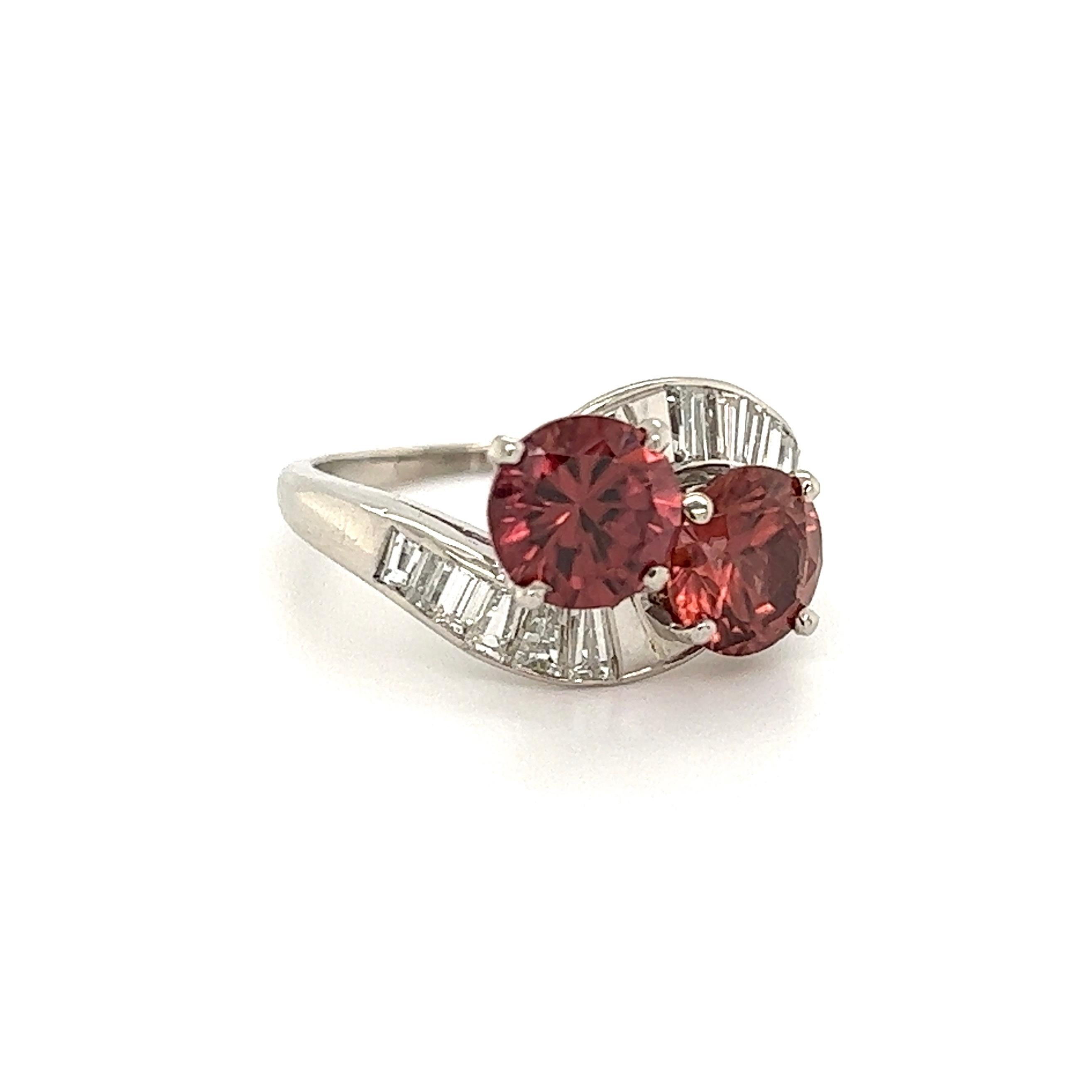 Beautiful 'Toi et Moi' Crossover Diamond and Blush Red Zircon Ring. Hand set with two Blush Red Zircon Gemstones, weighing 3.05tcw and baguette Diamonds weighing approx. 0.50tcw. Hand crafted Platinum mounting. Ring size: 5.25, we offer ring