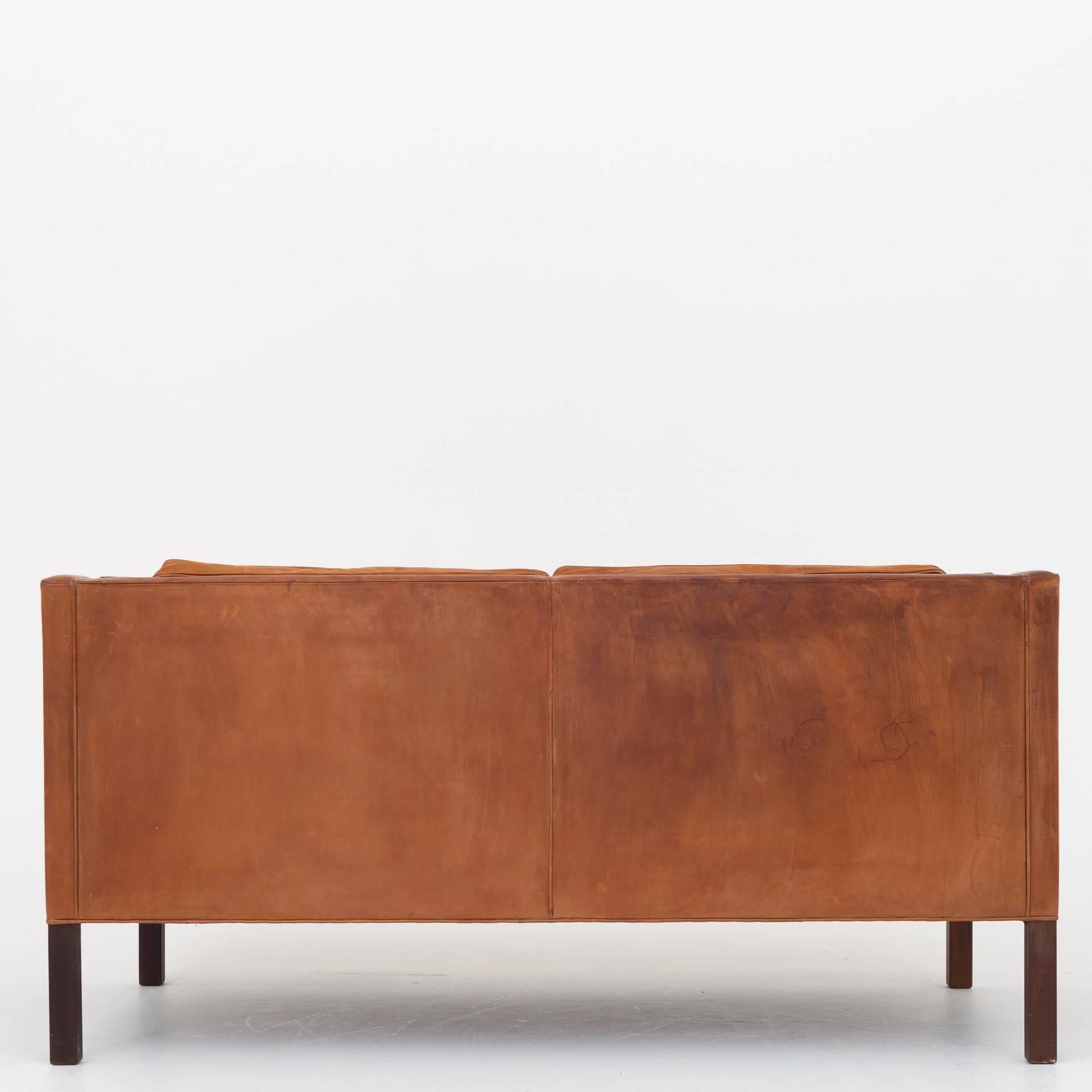 Sofa in patinated natural leather with legs in walnut. Maker Fredercia Furniture.
