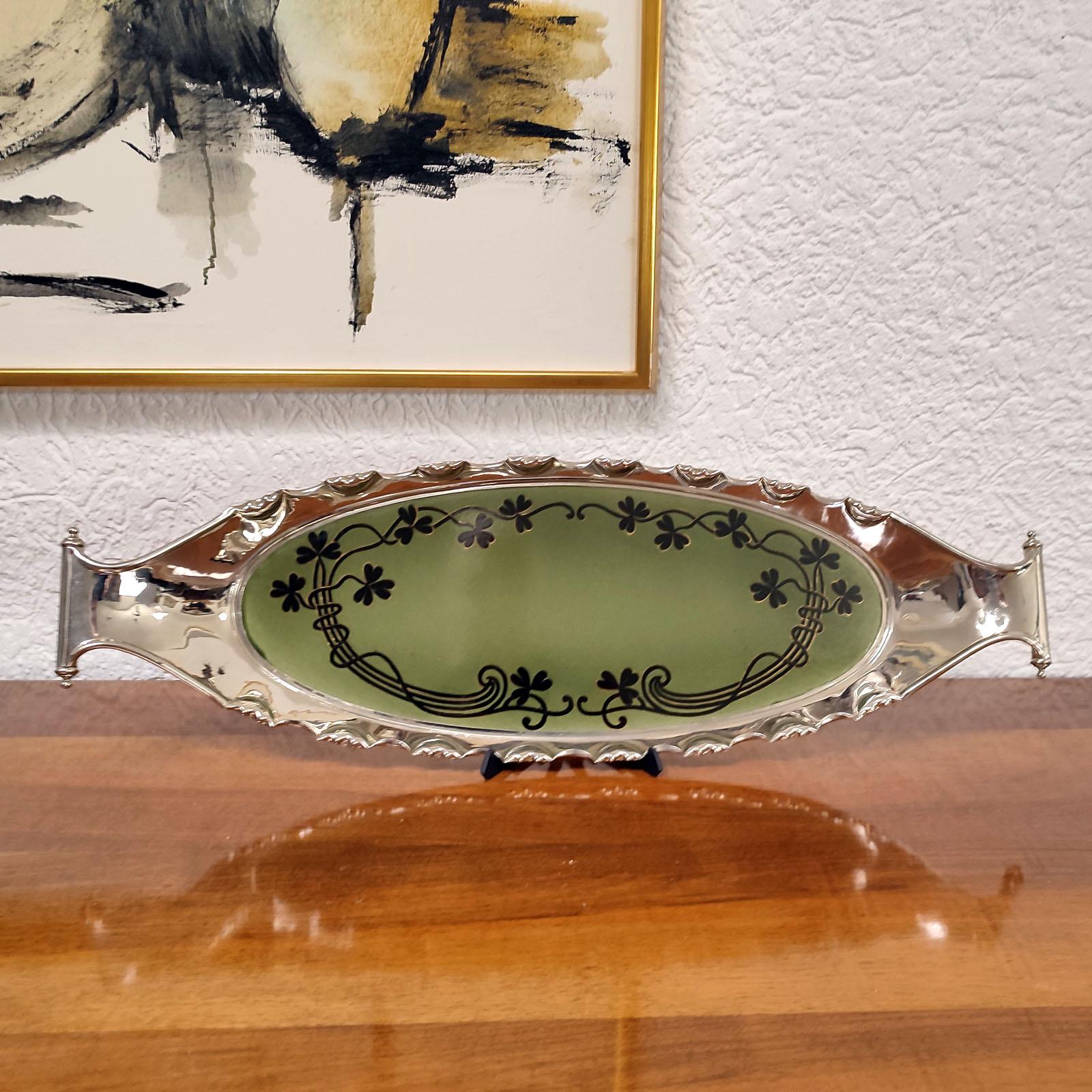 Enorme bandeja art nouveau de Villeroy & Boch, Dresde, Alemania, hacia 1900, con marco de metal atribuido a Bayerische Metallwarenfabrik Nuremberg-BMF.
Gres, ovalado, decoración Art Nouveau, vidriado verde oscuro transparente con zarcillos de trébol