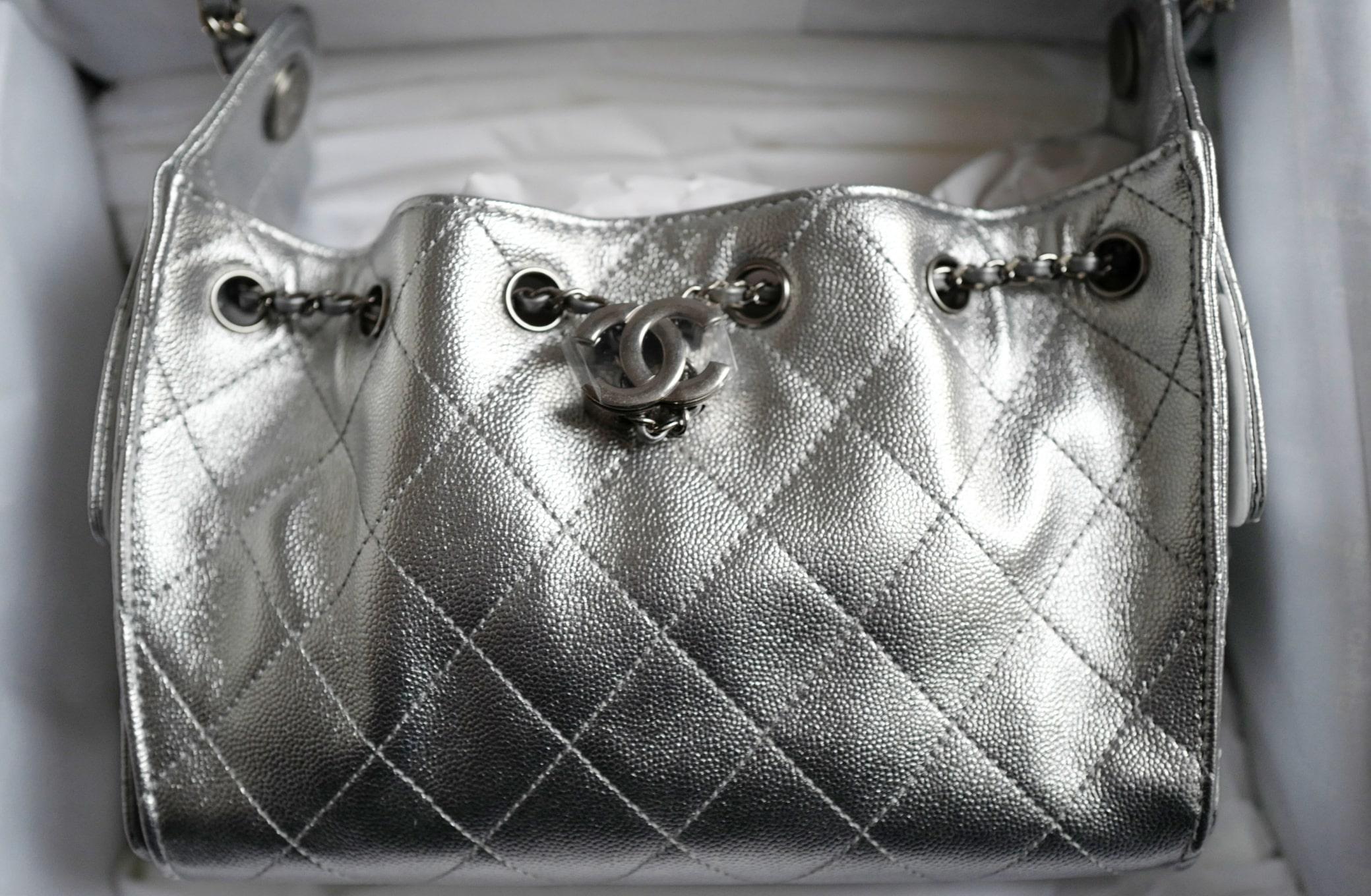 The Chanel 26C Mini Hobo Metallic Silver Grained Calfskin Shoulder Bag is a dazzling statement piece from Chanel’s Cruise 2026 collection. Crafted from luxurious grained calfskin, this bag showcases a stunning metallic silver hue that shimmers