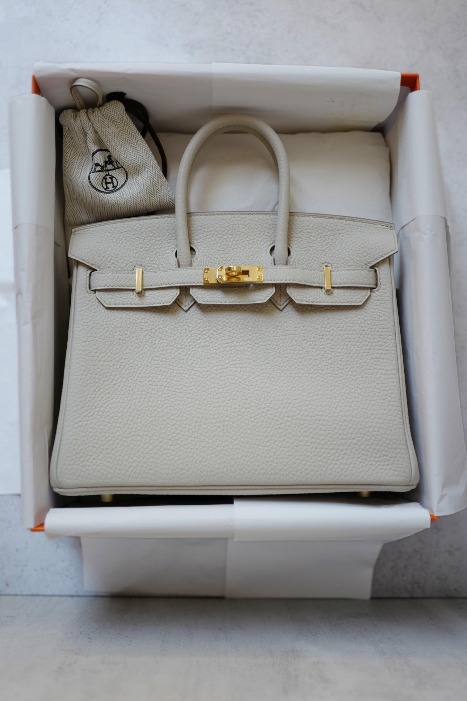 El Birkin 25 Hermès de piel Beton Veau Togo con herrajes dorados es el epítome del lujo y la elegancia atemporales. Confeccionado en piel Veau Togo flexible y duradera, este bolso icónico muestra la artesanía sin igual y el diseño refinado de
