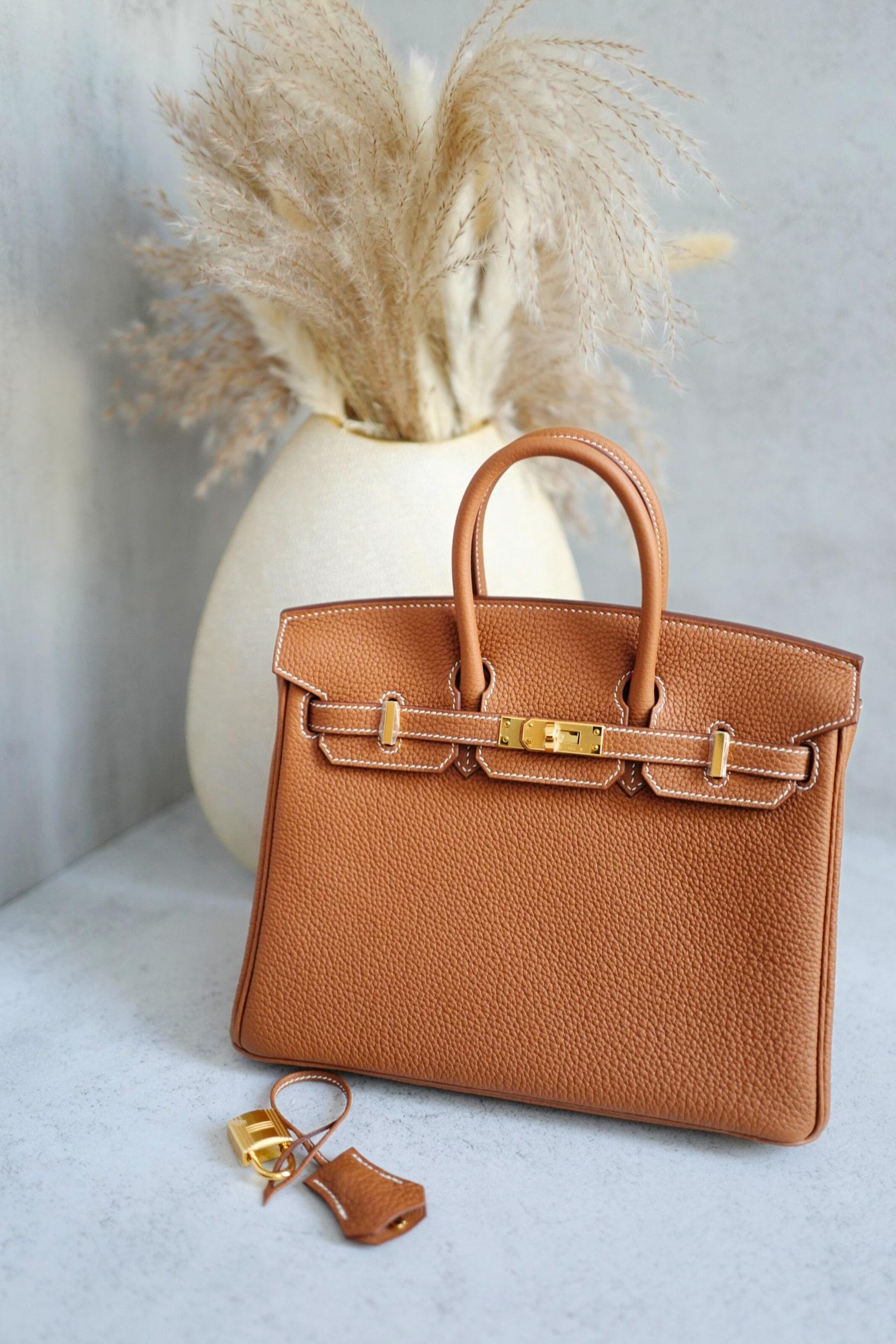 The Hermès Birkin 25 in Gold Togo with Gold Hardware is an enduring icon of sophistication and elegance. Crafted from luxurious Togo leather, this bag is renowned for its fine grain texture, durability, and timeless appeal. The warm 