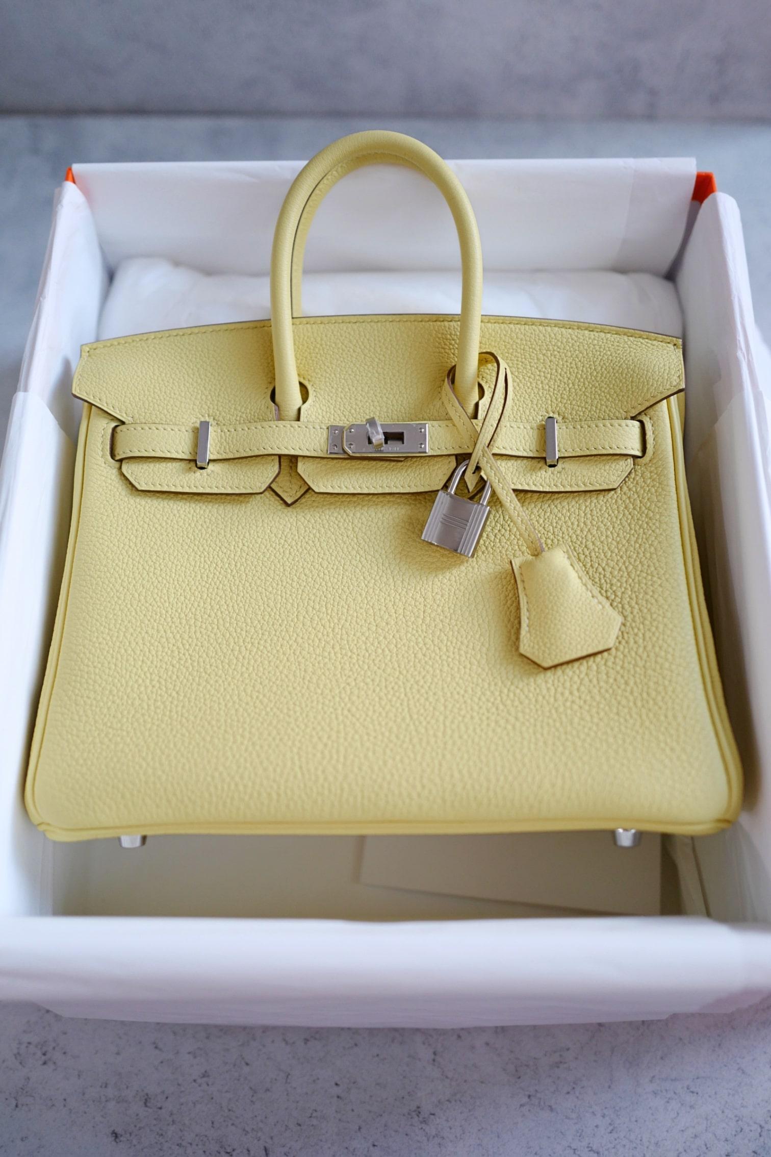 The Hermès Birkin 25 in Jaune Poussin is a timeless piece that combines refined craftsmanship with a cheerful pastel yellow hue. Made from Togo leather, known for its supple yet durable texture, this bag offers both elegance and practicality. The