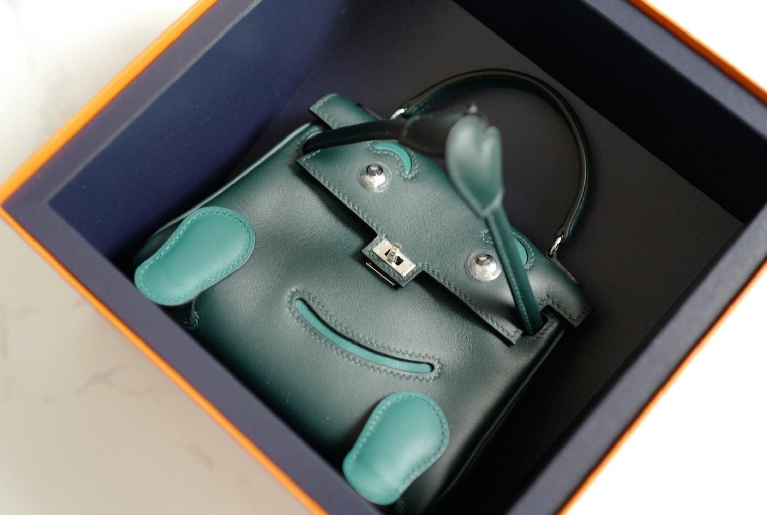 A Collector’s Dream. A Whimsical Icon Reimagined.

Step into the playful world of Hermès artistry with the Kelly Doll (Quelle Idole)—a rare and imaginative reissue of the house’s most charming creation. Crafted in Swift calfskin in a rich duet of