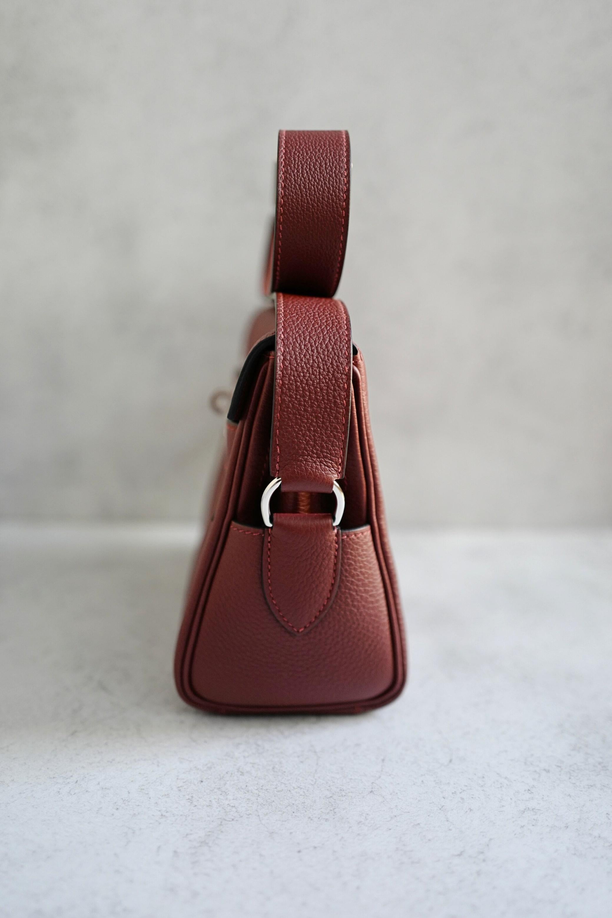 Diese Hermès Kelly Messenger PM aus hochwertigem Veau Togo-Kalbsleder verbindet die Tradition der kultigen Kelly-Silhouette mit dem praktischen Nutzen einer Crossbody-Messengertasche. Die satte Farbe Rouge H strahlt unaufdringlichen Luxus und