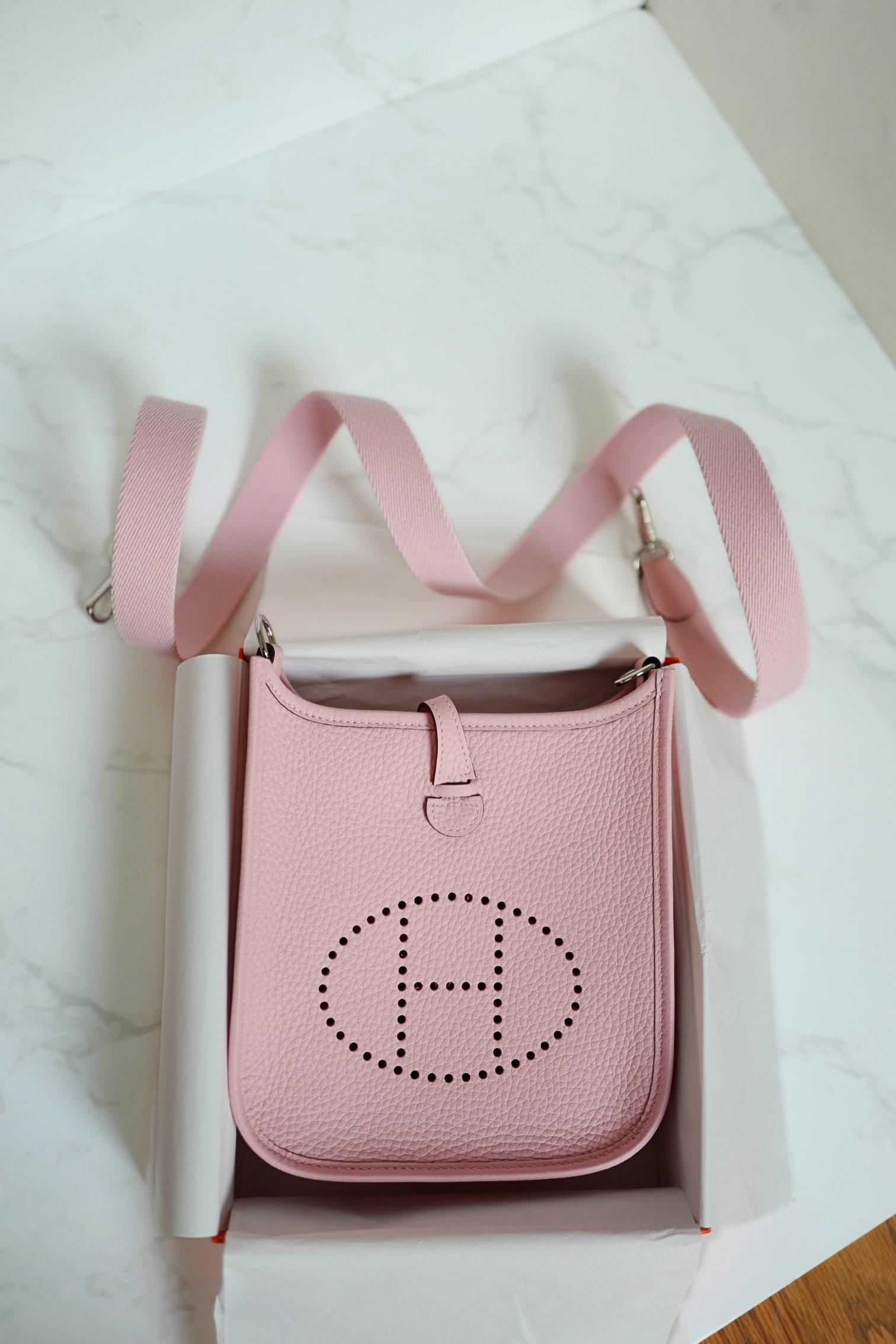 L'Elegès Mini Evelyne TPM in Rose Sakura con Hardware Palladium è un accessorio senza tempo che incarna perfettamente eleganza e funzionalità. Realizzata in morbida pelle Clemence, questa affascinante borsa crossbody presenta l'iconico logo 