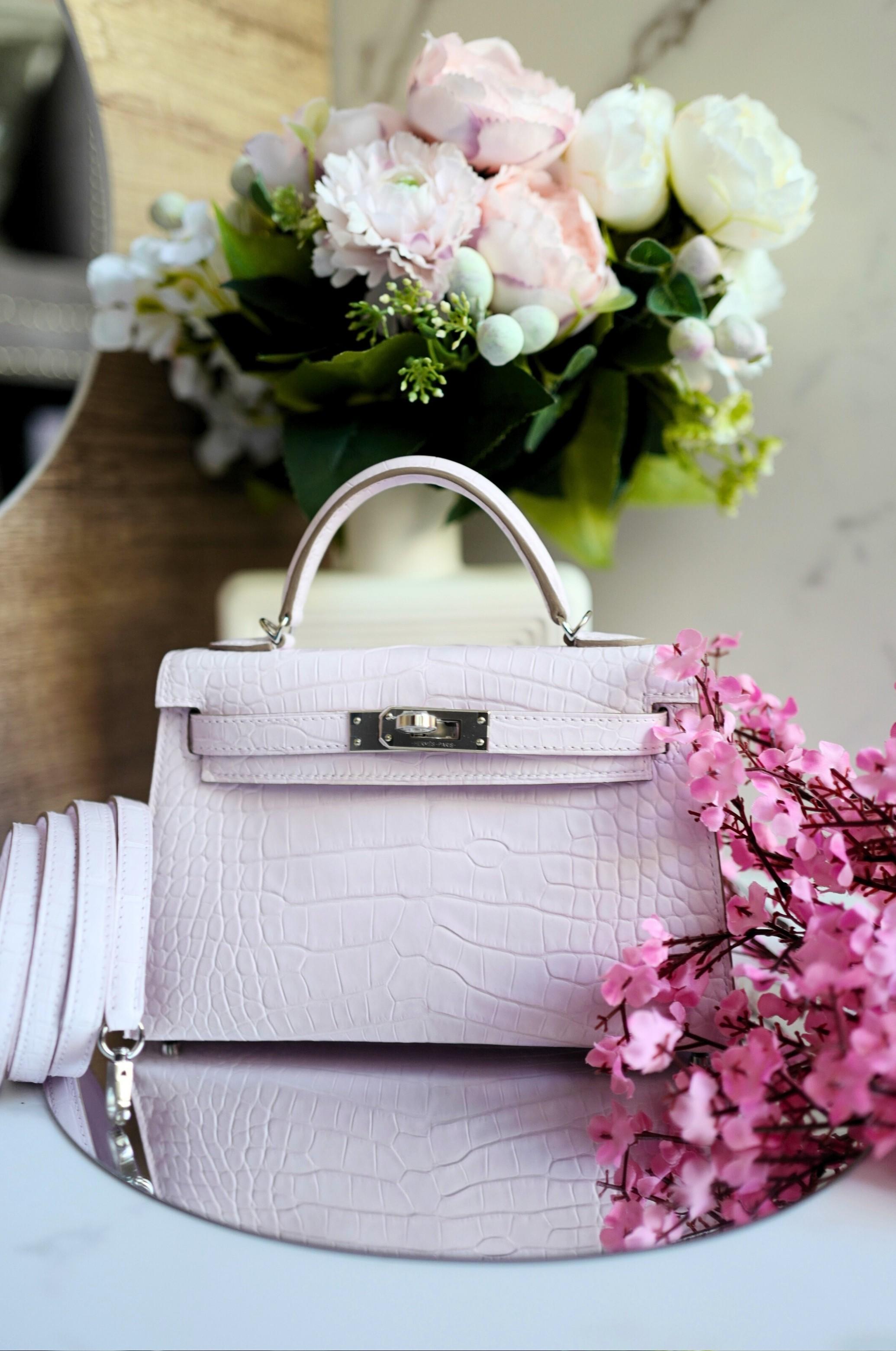 Immersa nella più tenue tonalità di malva, questa Mini Kelly di Hermès è un sussurro di grazia e femminilità, catturato nella rara bellezza della pelle di alligatore opaca. La sua delicata tonalità danza tra il rossore e la serenità, evocando la