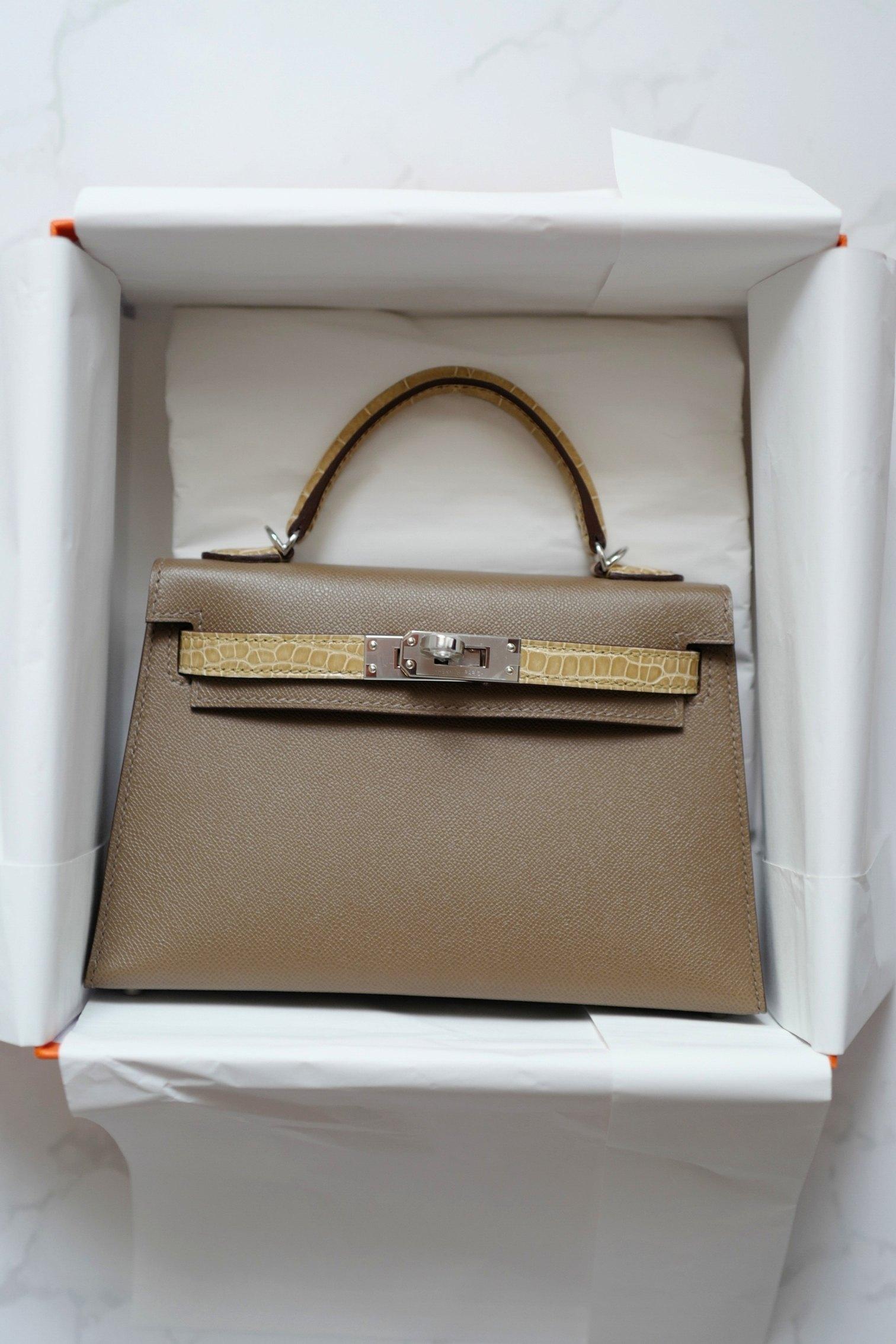 Elevate your collection with the ultimate symbol of refined elegance—the Brand New in Box Hermès Mini Kelly Touch in Etoupe/beige sable with Palladium Hardware. This extraordinary piece pairs the house’s impeccable craftsmanship with a rare and
