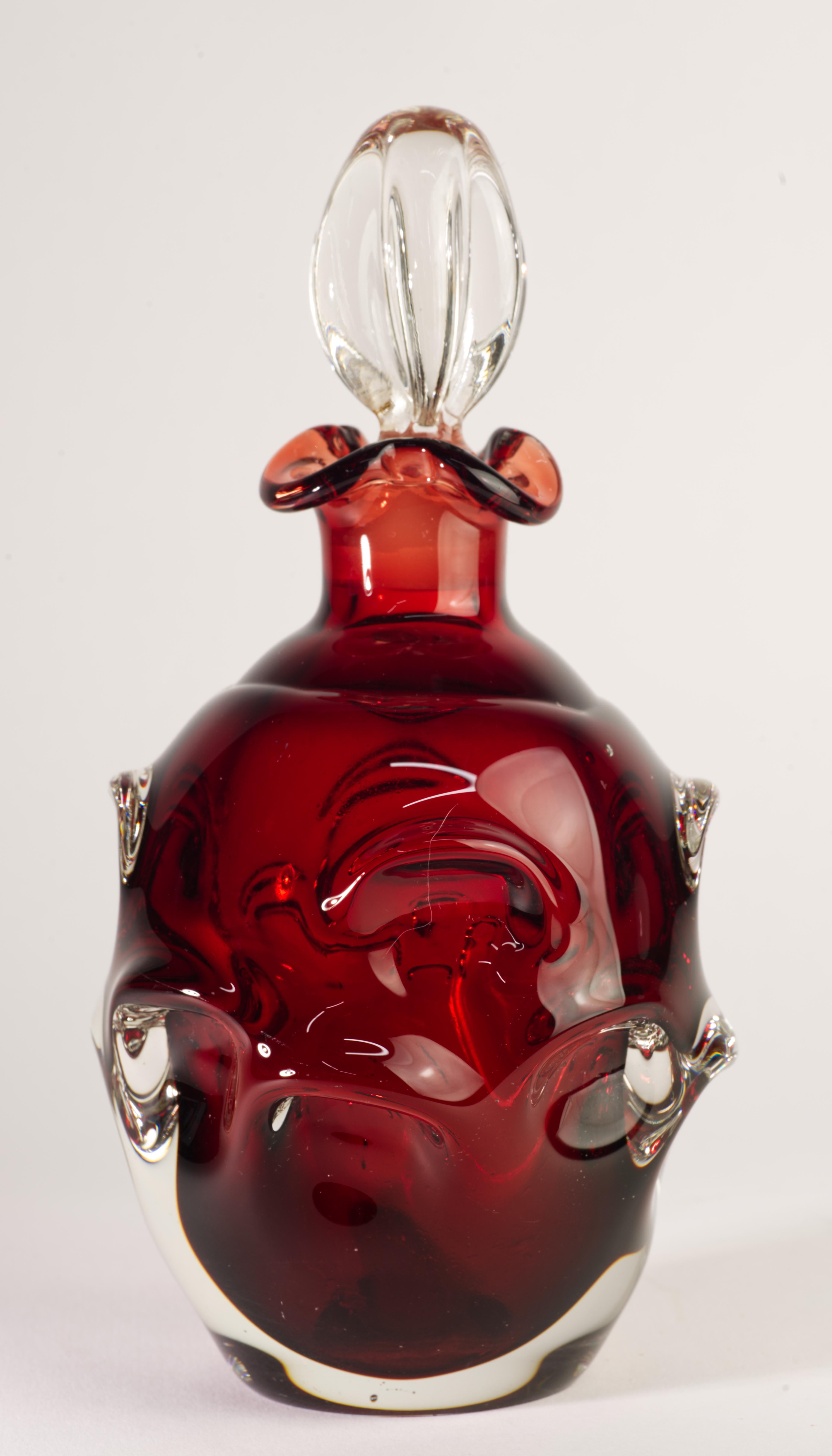  La jarra vintage de vidrio sommerso fue diseñada por Bo Bergstrom para Aseda Glasbruk, Suecia, en la década de 1960. El vidrio rojo rubí está recubierto de vidrio transparente en técnica de sommerso, mostrando la compleja forma orgánica de la