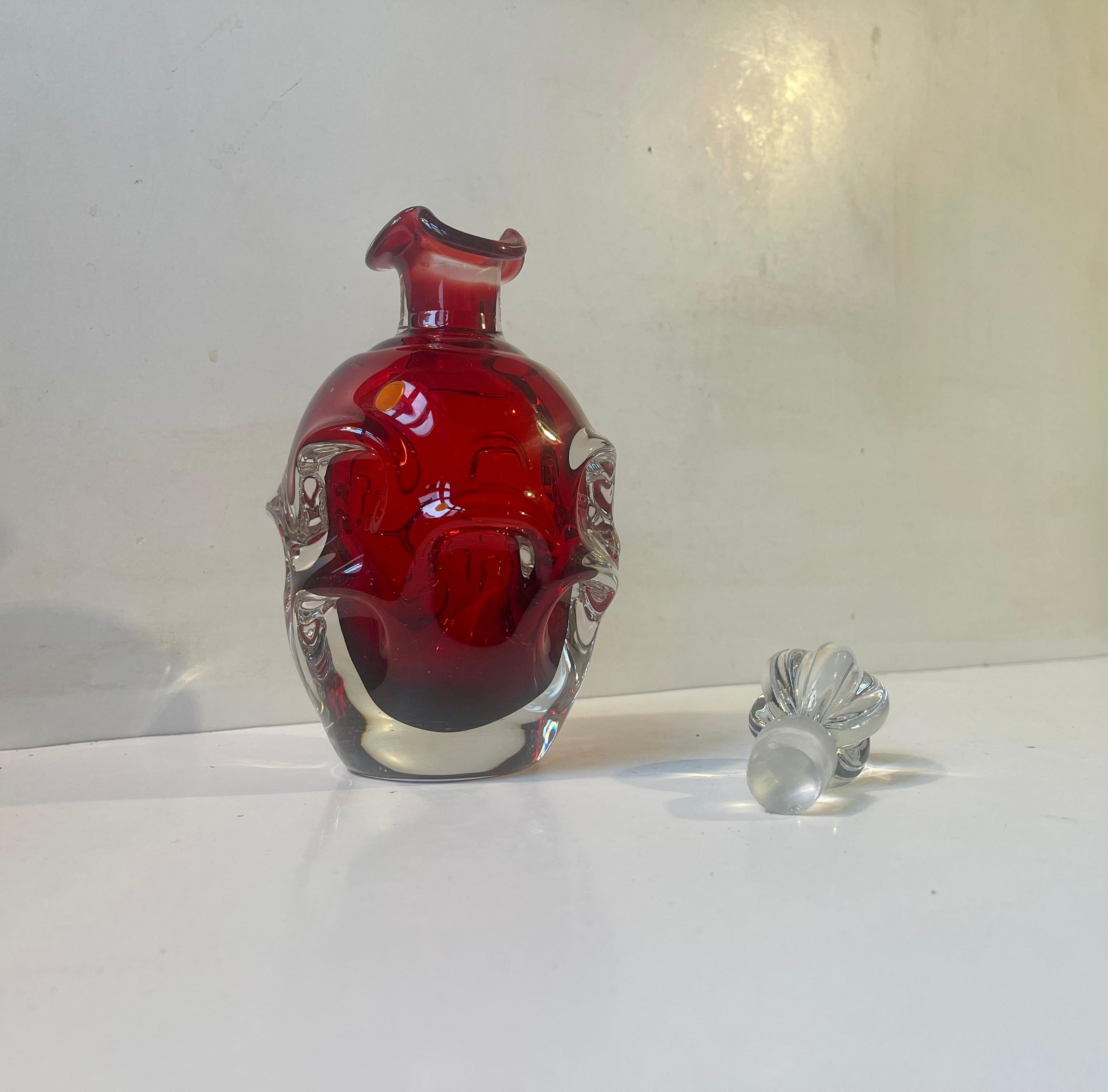 A ruby red Sommerso Glass decanter designed and hand-made by Swedish Bo Bergstrom at ASEDA Glasbruk in Sweden during the 1960s. Its a heavy piece made from thick glass mass. Measurements: H: 24 cm, W/D: 11 cm. Capacity: 0,7 liter.  
Well-kept and