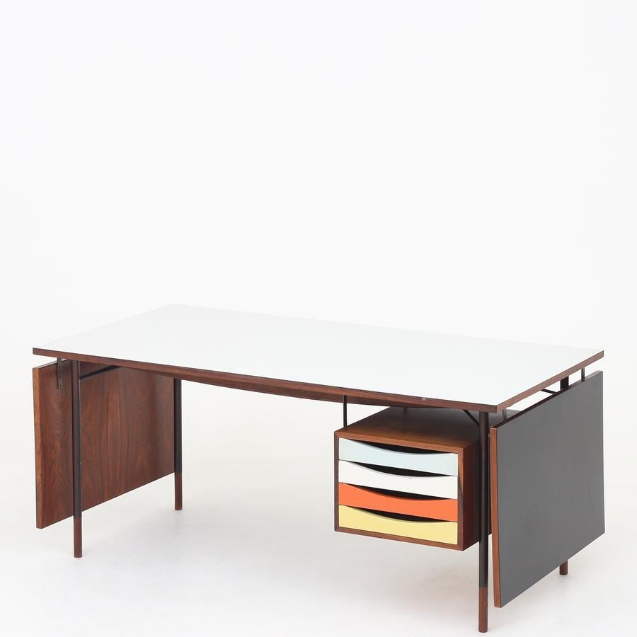 BO 69 - Rare desk/work table in rosewood, light and black laminate. Black metal frame and teak shoes. Drawer module in rosewood with original, colored drawers. Total length 250 cm. Designed in 1953. Maker Bovirke.