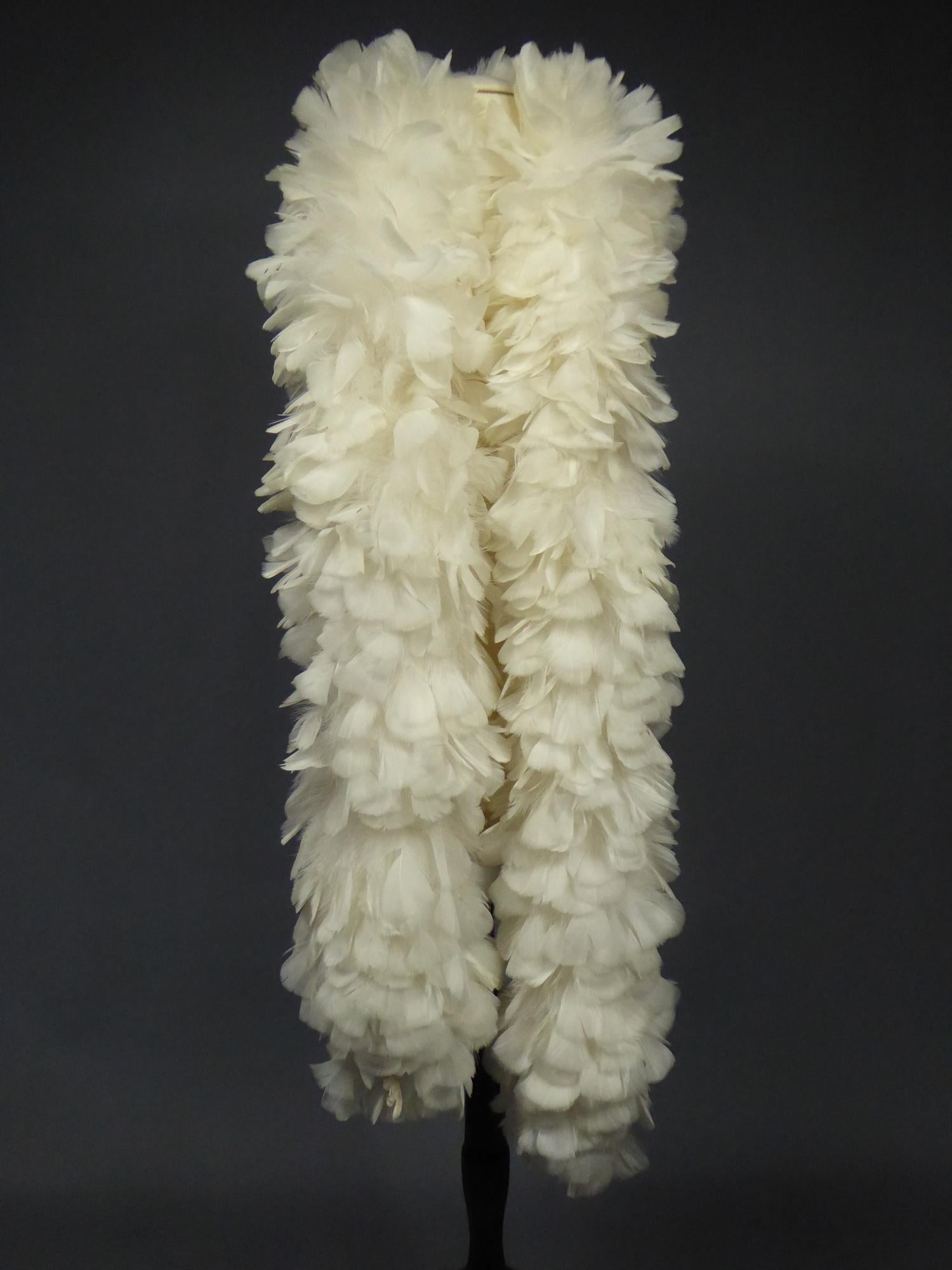 Circa 2000
France

Long boa stole in white cockerel feathers dating from the 2000s. Knotted inside assembly in fluff feathers and finished at each end with a small braided cotton rope. No tasks, very clean, very solid feathers structure. Very good