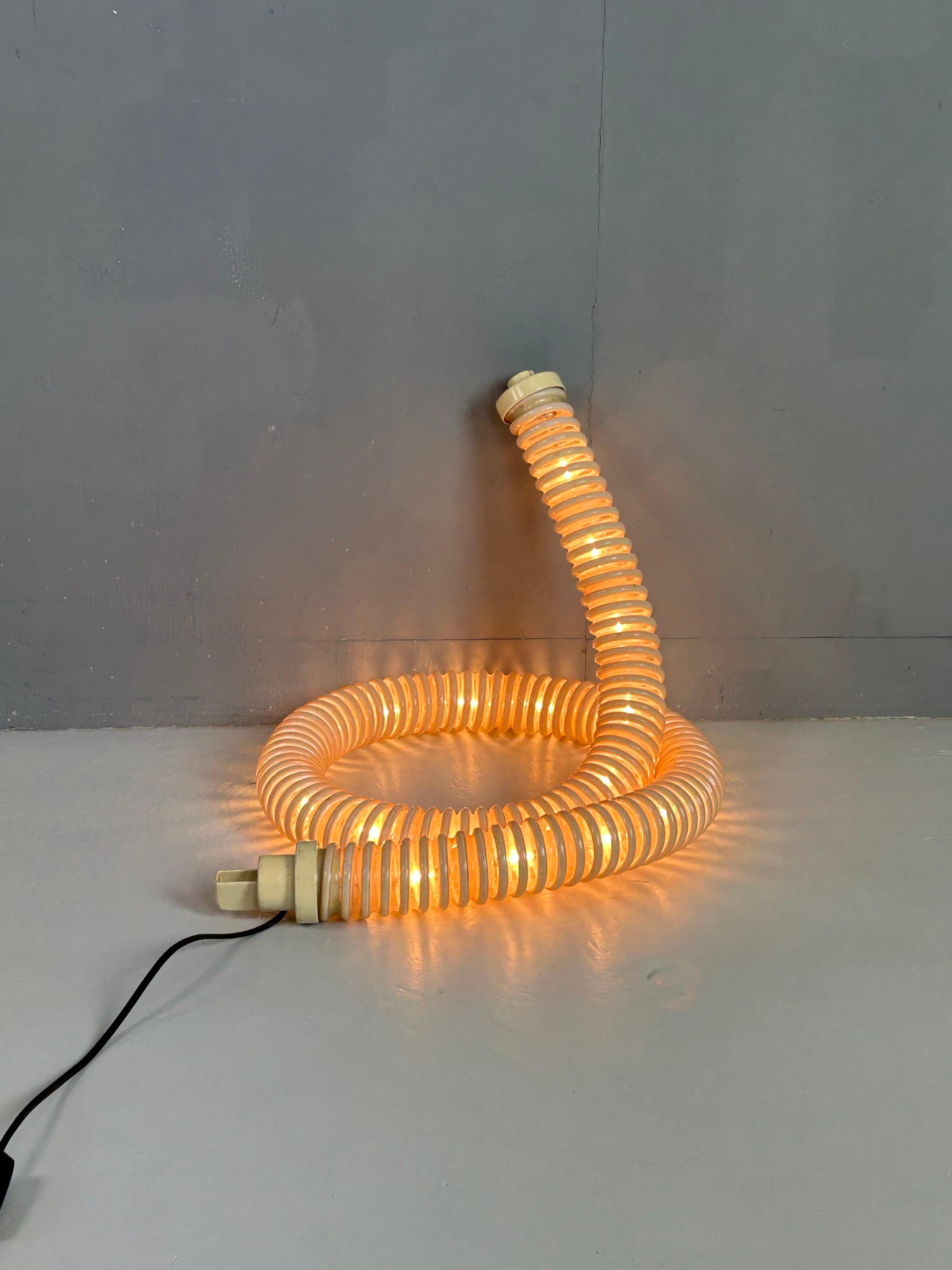 Esta impresionante lámpara Boalum, diseñada en 1970 por Gianfranco Frattini y Livio Castiglioni para Artemide, es un icono atemporal del diseño de iluminación italiano. La lámpara está compuesta por una estructura tubular flexible de plástico