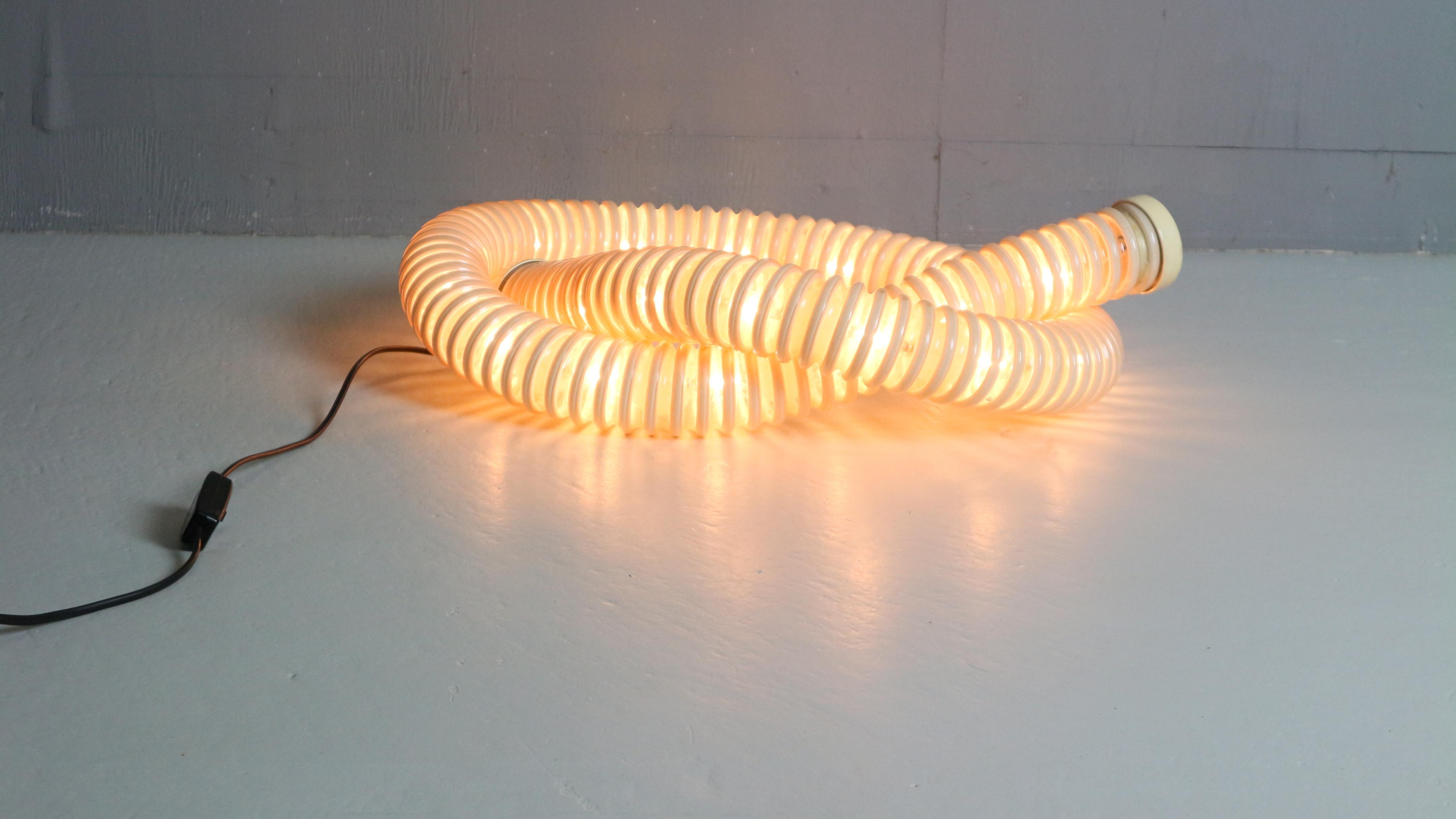 This stunning Boalum lamp, designed in 1970 by Gianfranco Frattini and Livio Castiglioni for Artemide, is a timeless icon of Italian lighting design. The lamp is composed of a flexible tubular structure made from translucent plastic, allowing it to