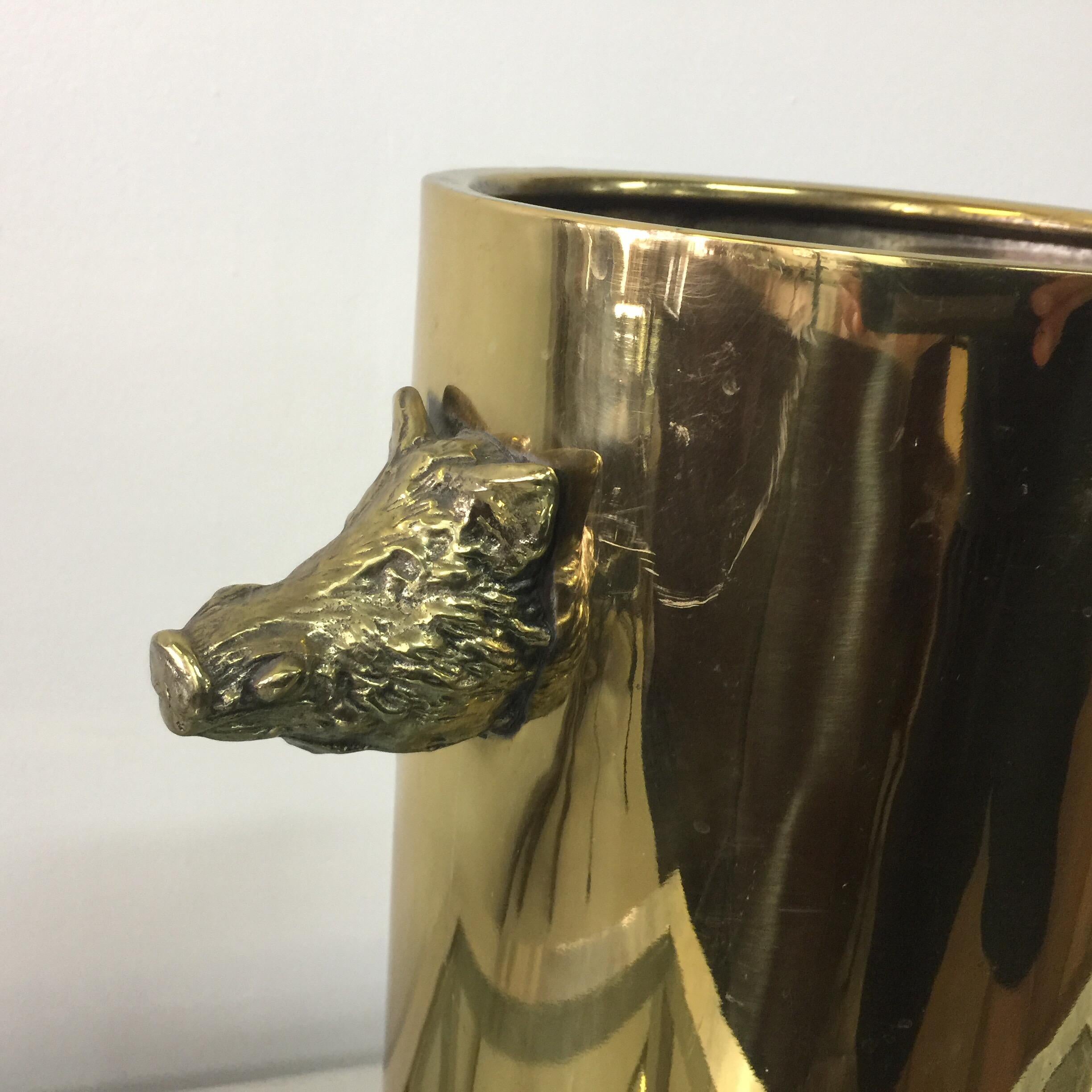Beautifully detailed boars heads adornment on brass cylinder vessel for umbrellas.