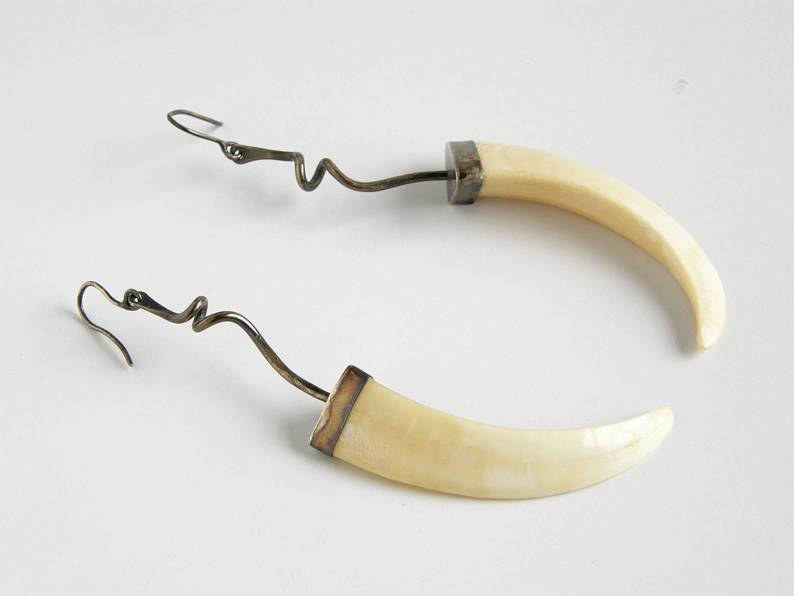 These dramatic earrings by Chicago jeweler Ted Drendel beautifully combine ancient and modern elements. The fierce looking boar tusks are countered by the whimsical, irregular coils from which they hang. Boar tusks have various significance in many