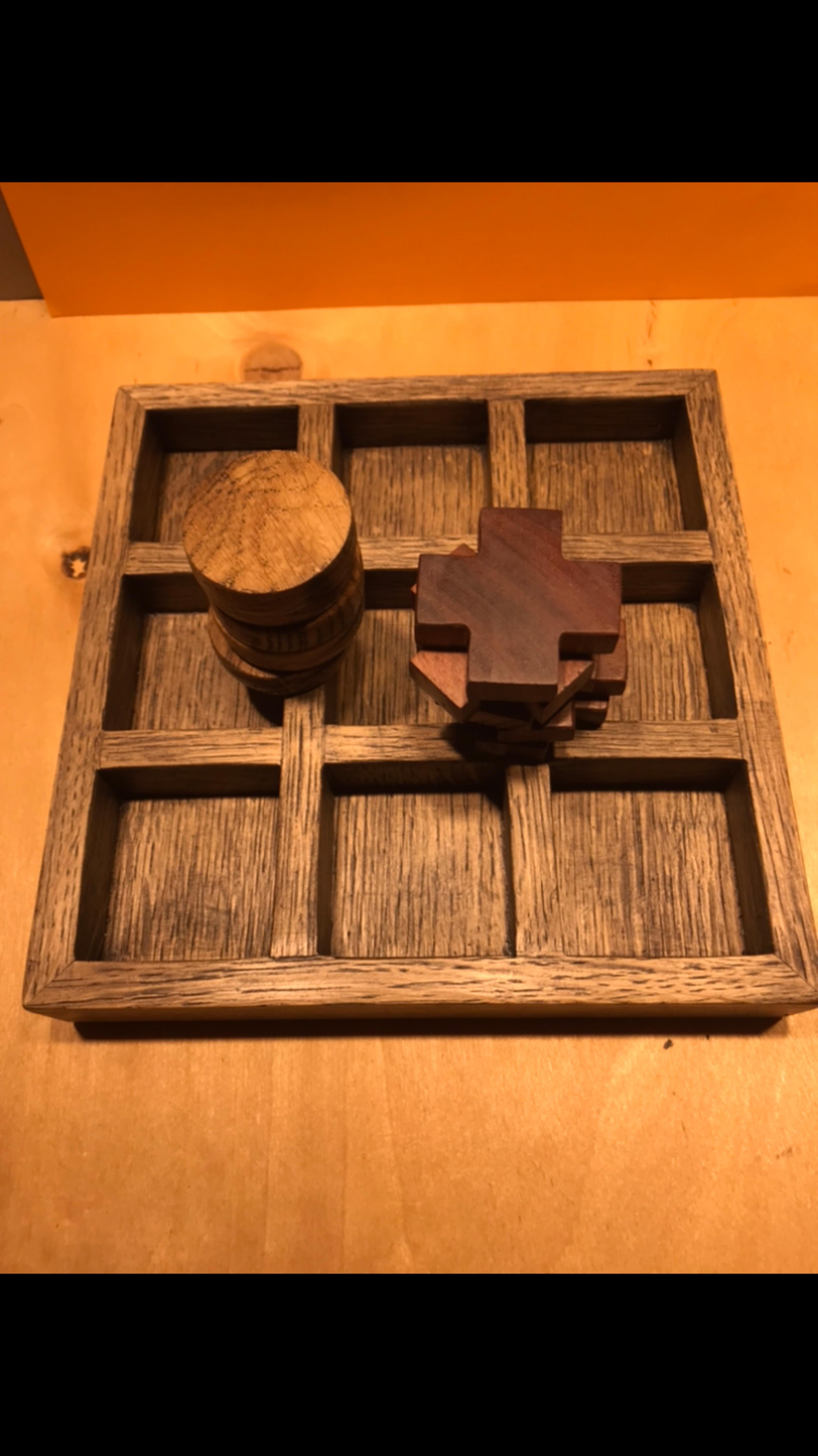 The board game tic-tac-toe is made by hand, the board is made using white oak veneer, the toes are entirely made of oak, the crosses are made of mango wood, and the board and game elements are coated with oil