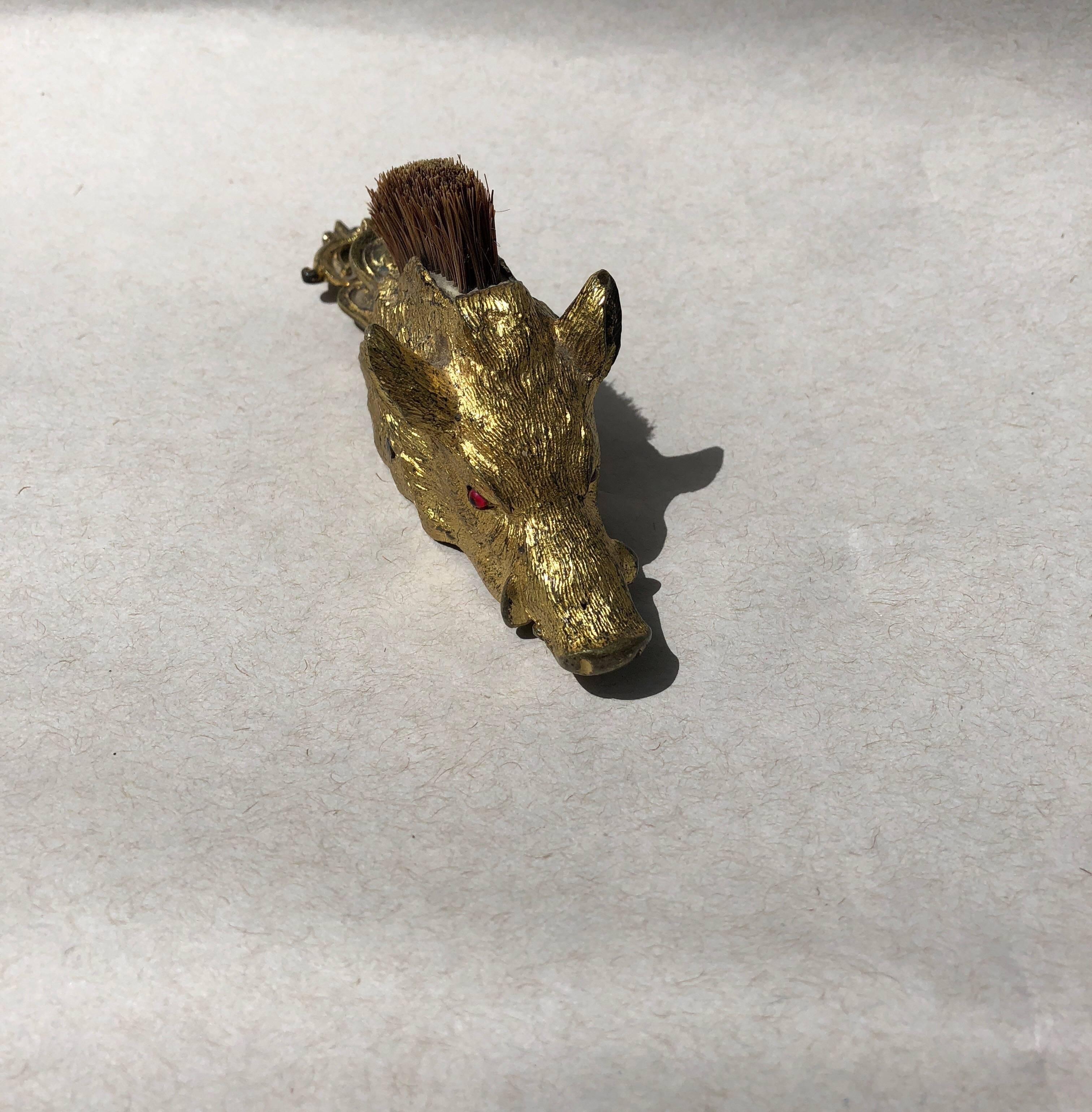 Victorian brass boar's head-form paper clip with glass eyes and brush.