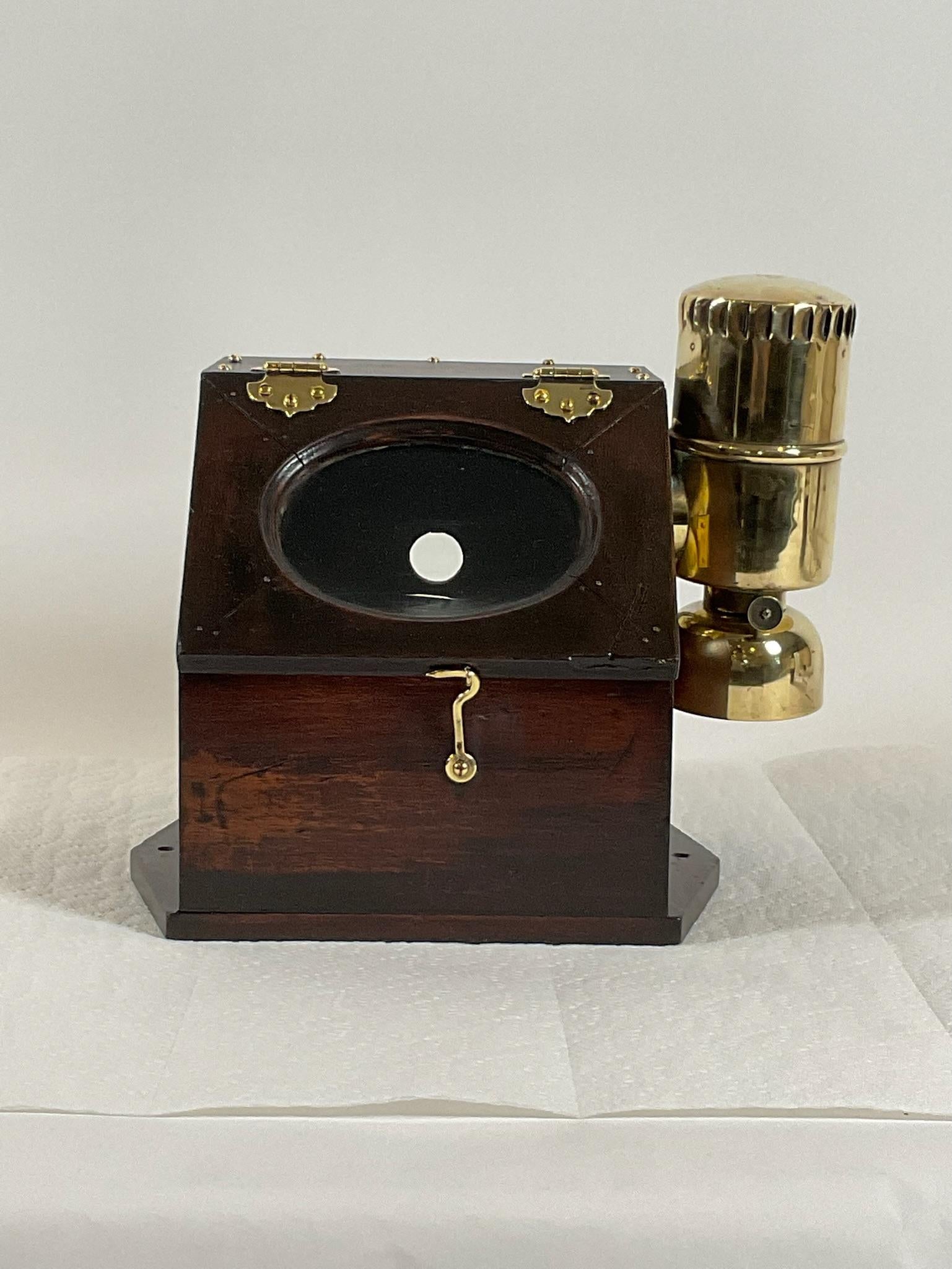 Rare yacht binnacle with a highly polished gimballed compass fitted to a varnished box. The box has a polished brass side burner and hinges, hooks, and screws. First class nautical relic. Signed by George A Baker, Melrose Mass.

Weight: 9
