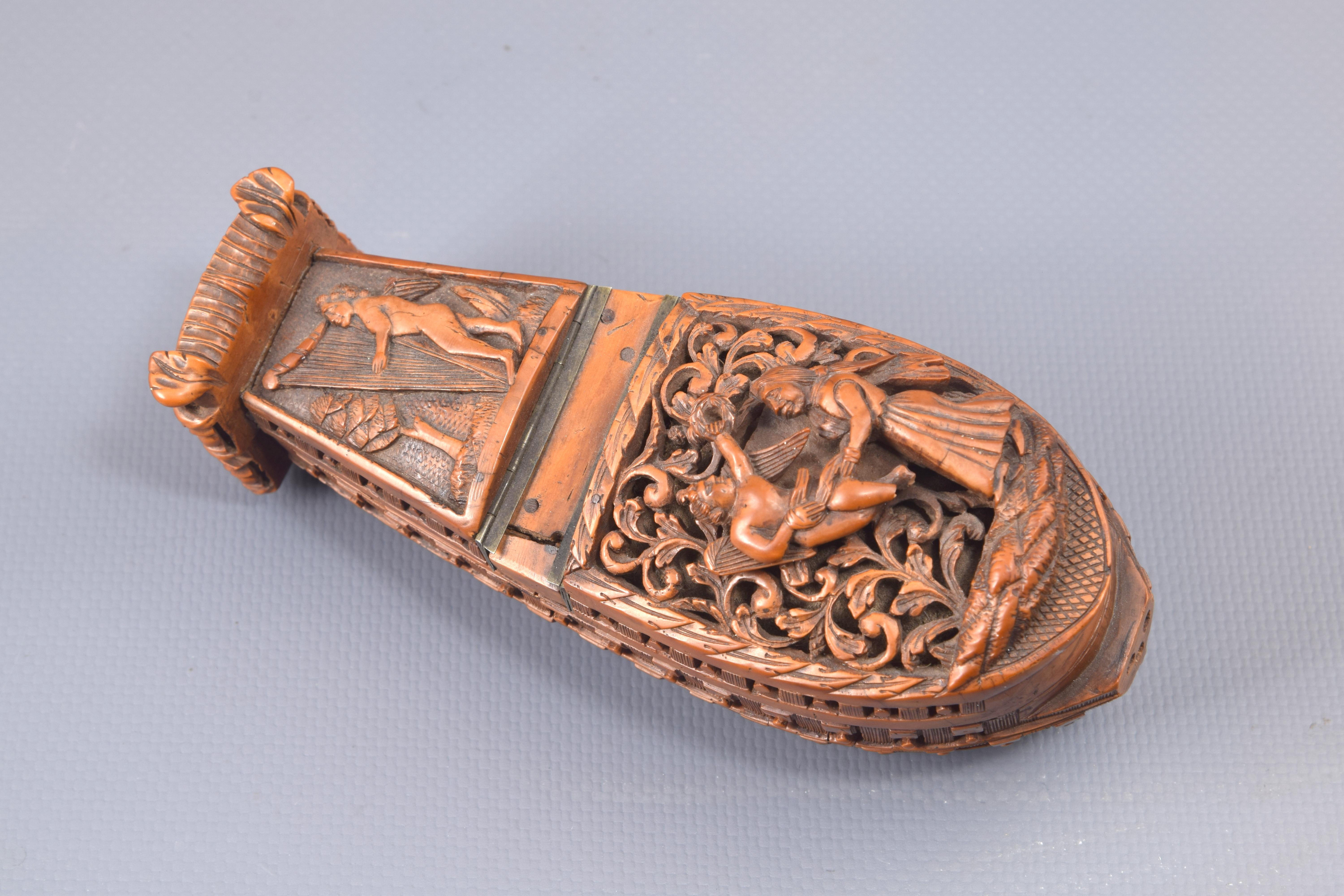 Snuffbox. Boxwood, Century XVIII.
 Box or snuff box made of carved boxwood and metal worked to have the shape of a ship, with the lower part decorated with garlands and the front with three rows of cannons; note the work present in what would be