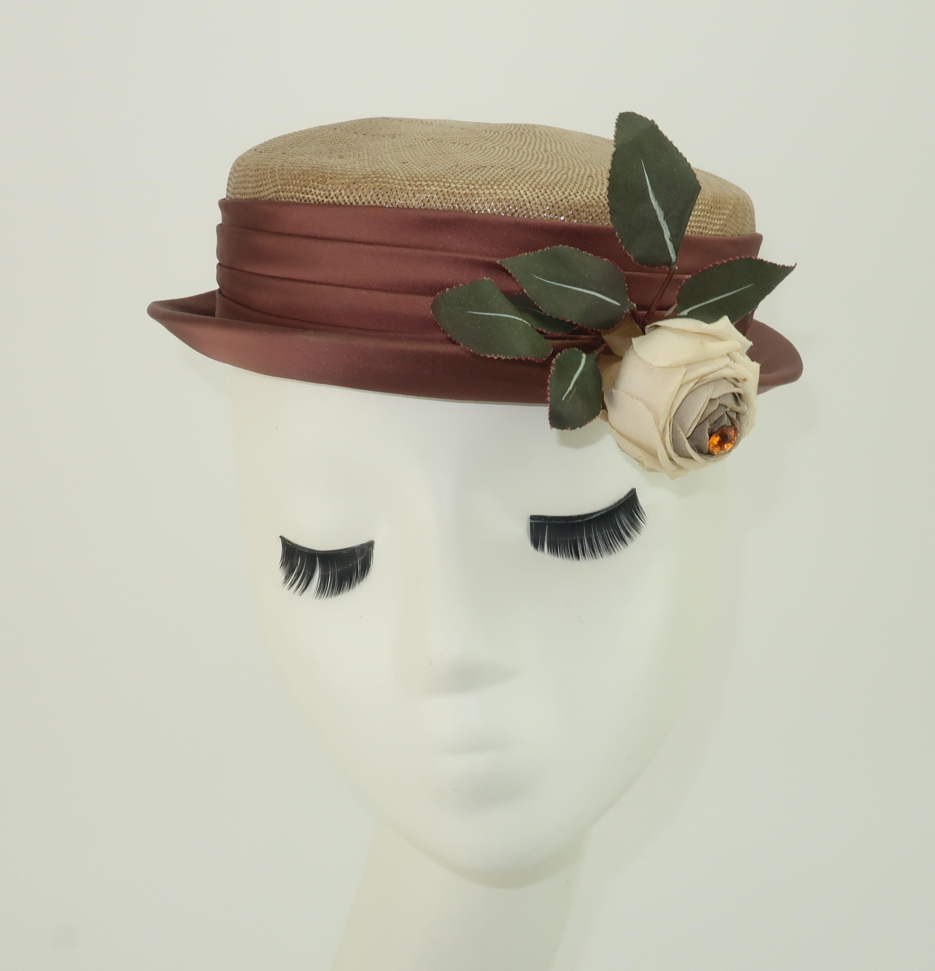Charming 1940's straw hat in a light tan or fawn shade with taupe brown ruched satin band and a natural white silk rose embellished with an amber stone.  The hat silhouette is somewhere between a modified boater and a pork pie style.  It is adorable