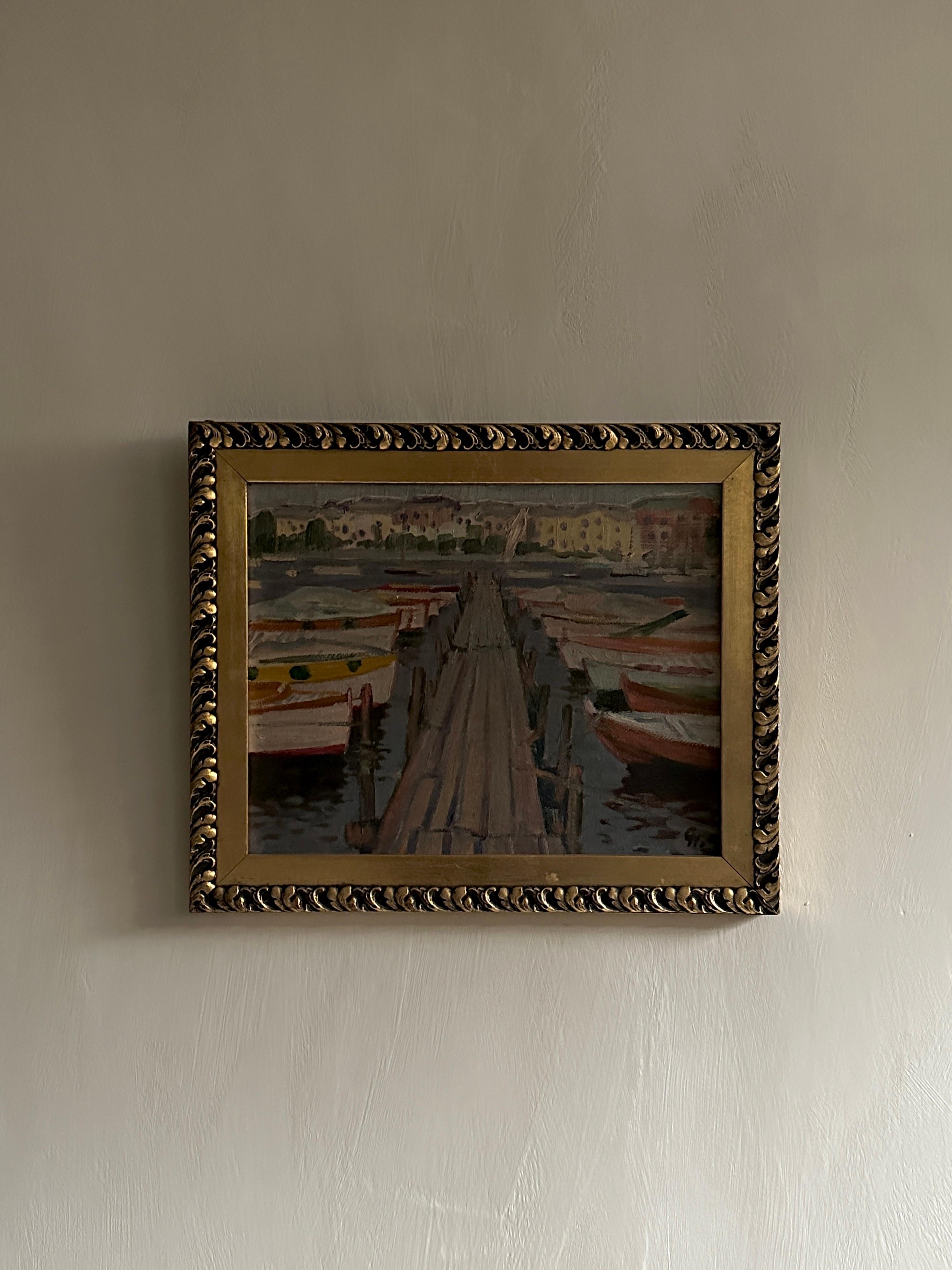 A melancholy painting of boats on a port. Oil on wood panel, signed and framed. Norway c. early 1900s.
