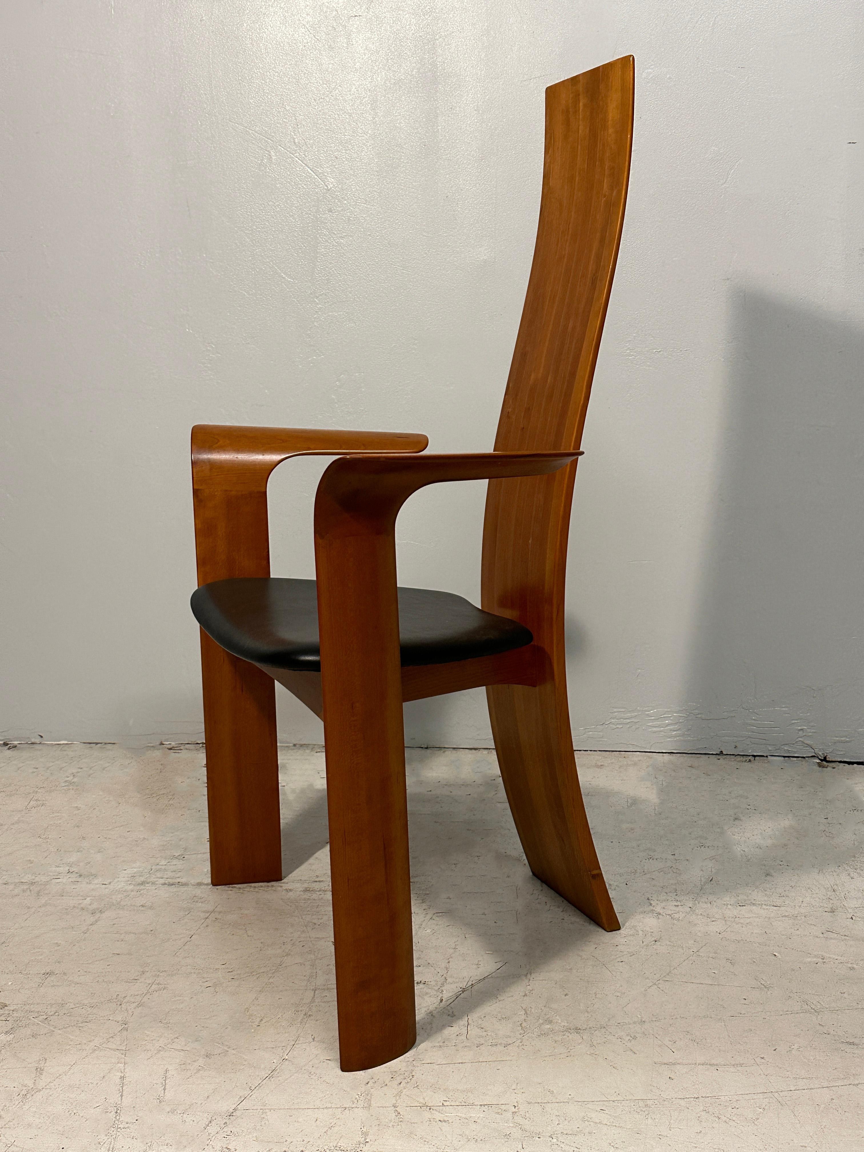 These impressive high-back dining chairs have teak legs and base, and their back juxtaposes different wood stripes: cherry, oak, walnut, and teak. The seats are upholstered in black leather.
The two armchairs and four side chairs identify as the