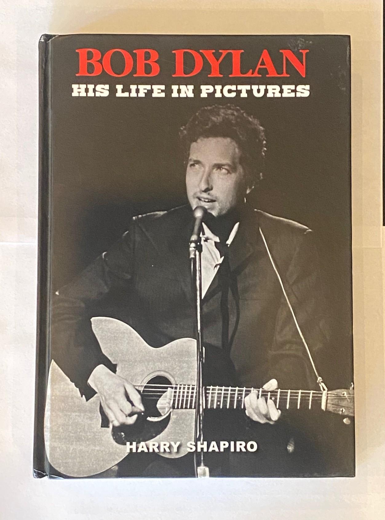 Un magnifique et extrêmement rare livre de photographies signé par Bob Dylan.  Le livre est l'œuvre du célèbre photographe Harry Shapiro, spécialiste de Dylan, et s'intitule 