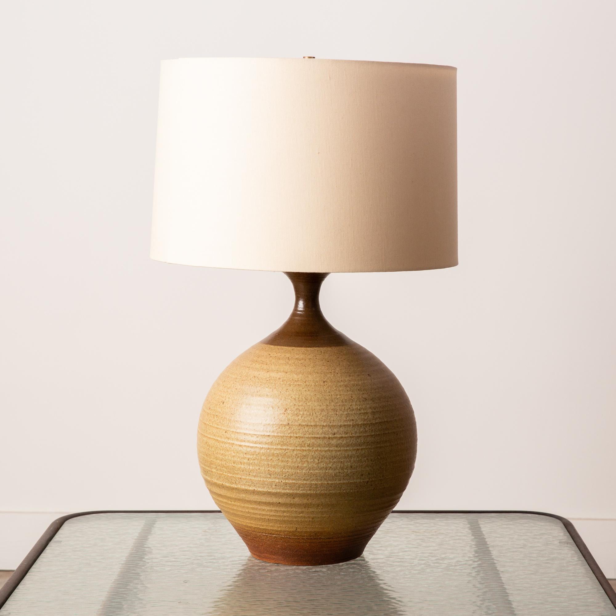 A large stoneware lamp by California ceramicist Bob Kinzie for his company, affiliated craftsmen. The wheel-thrown curved body of the ceramic lamp is lightly ribbed in texture and has a brown color-blocked band at the base and where the vessel