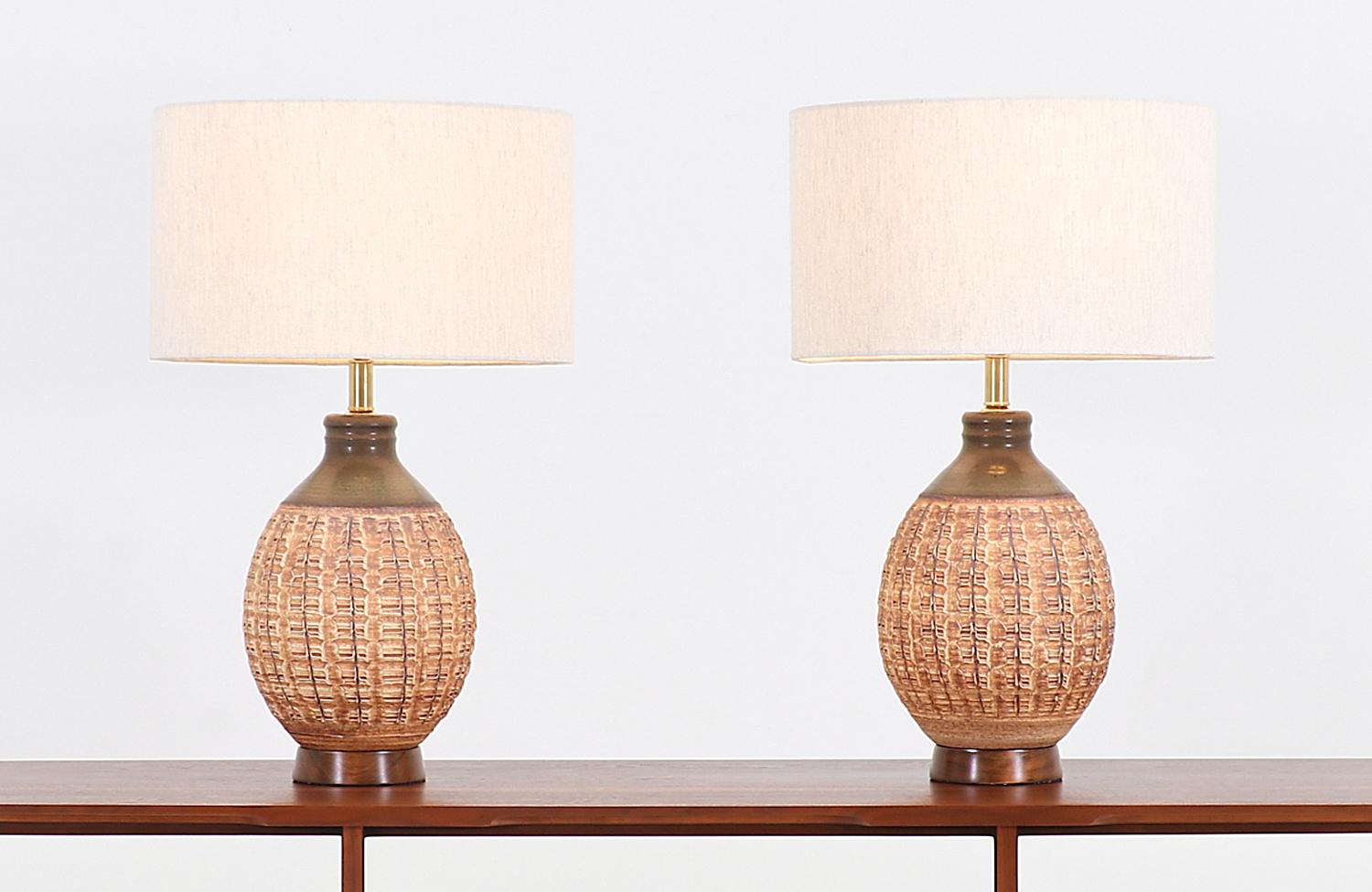 Pair of ceramic table lamps designed by Bob Kinzie for Affiliated Craftsmen in the United States, circa 1960s. These iconic N-series lamps showcase excellent craftsmanship on a rounded body with textured finish throughout. They feature warm colors,