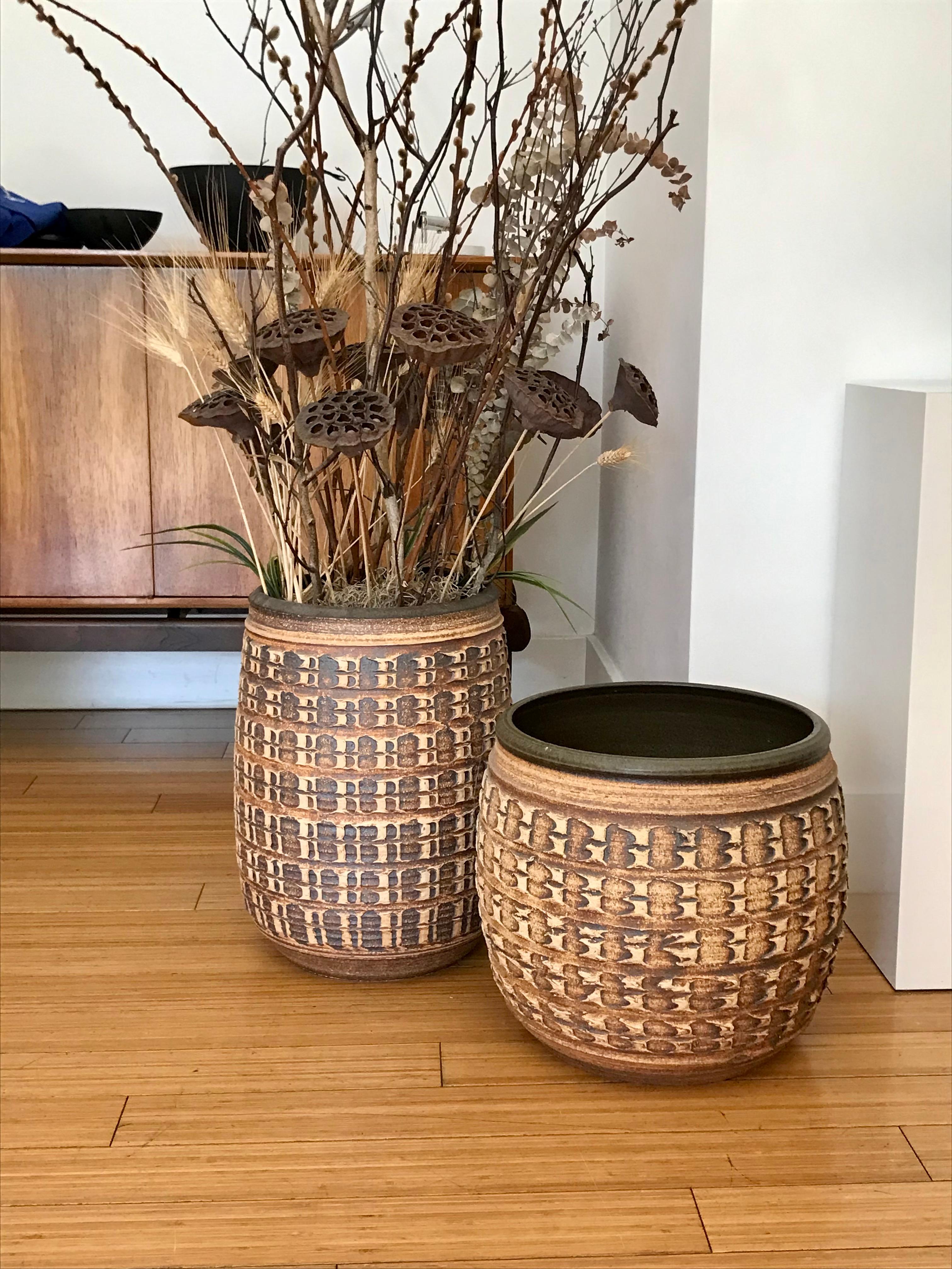 Handsome pair of 'Affiliated Craftsman' California design planters.
Wheel thrown natural clay on the outside with hand tooled pattern design, and glazed on the inside.
No drain holes.
No cracks, chips nor repairs.
Great original condition.
The