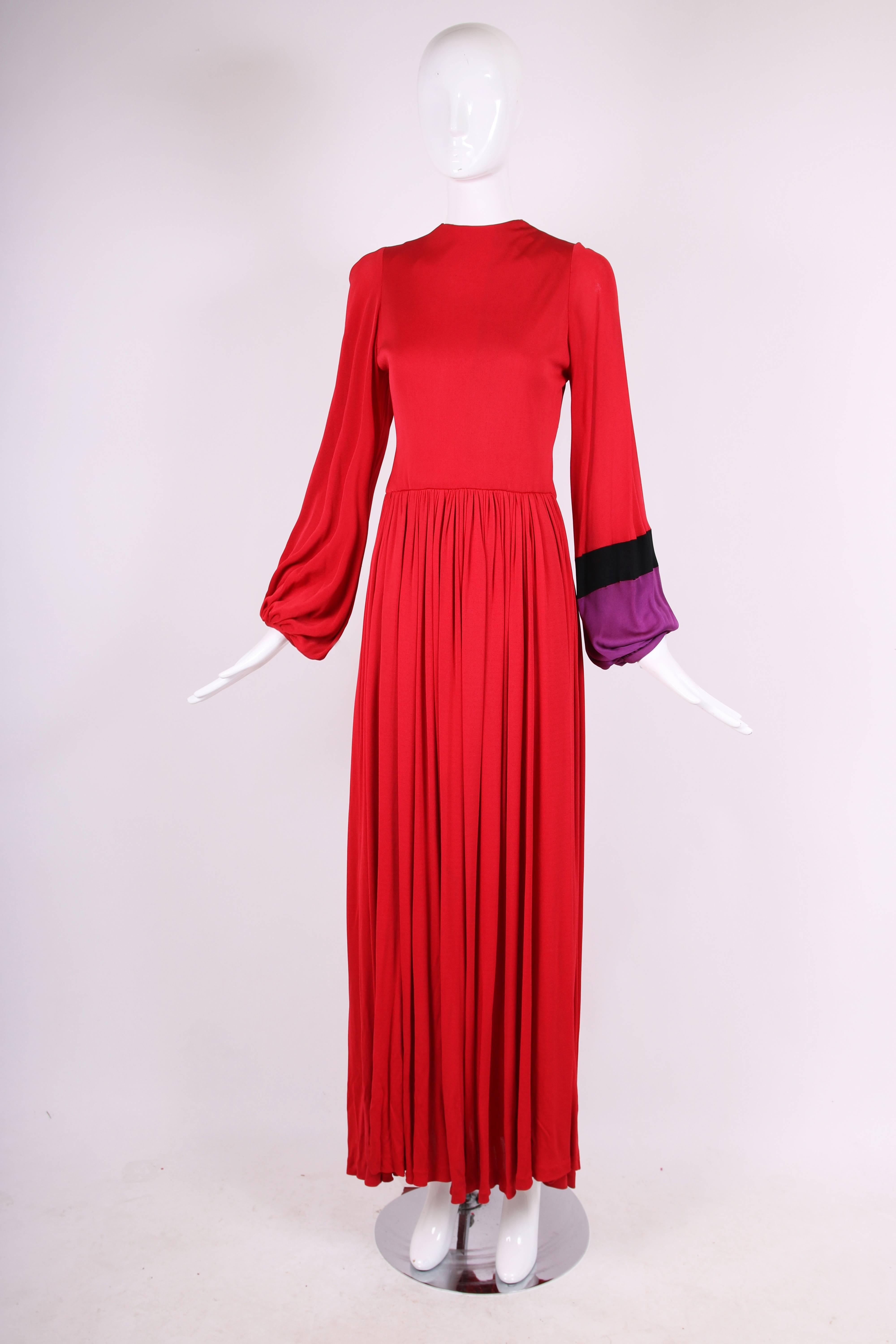 Bob Mackie & Ray Aghayan red jersey maxi dress with one sleeve and cuff in black and purple. Dress has mini scoop neckline, gathers at the waist and full balloon-type sleeves near the cuff. The dress is in good vintage condition but with several