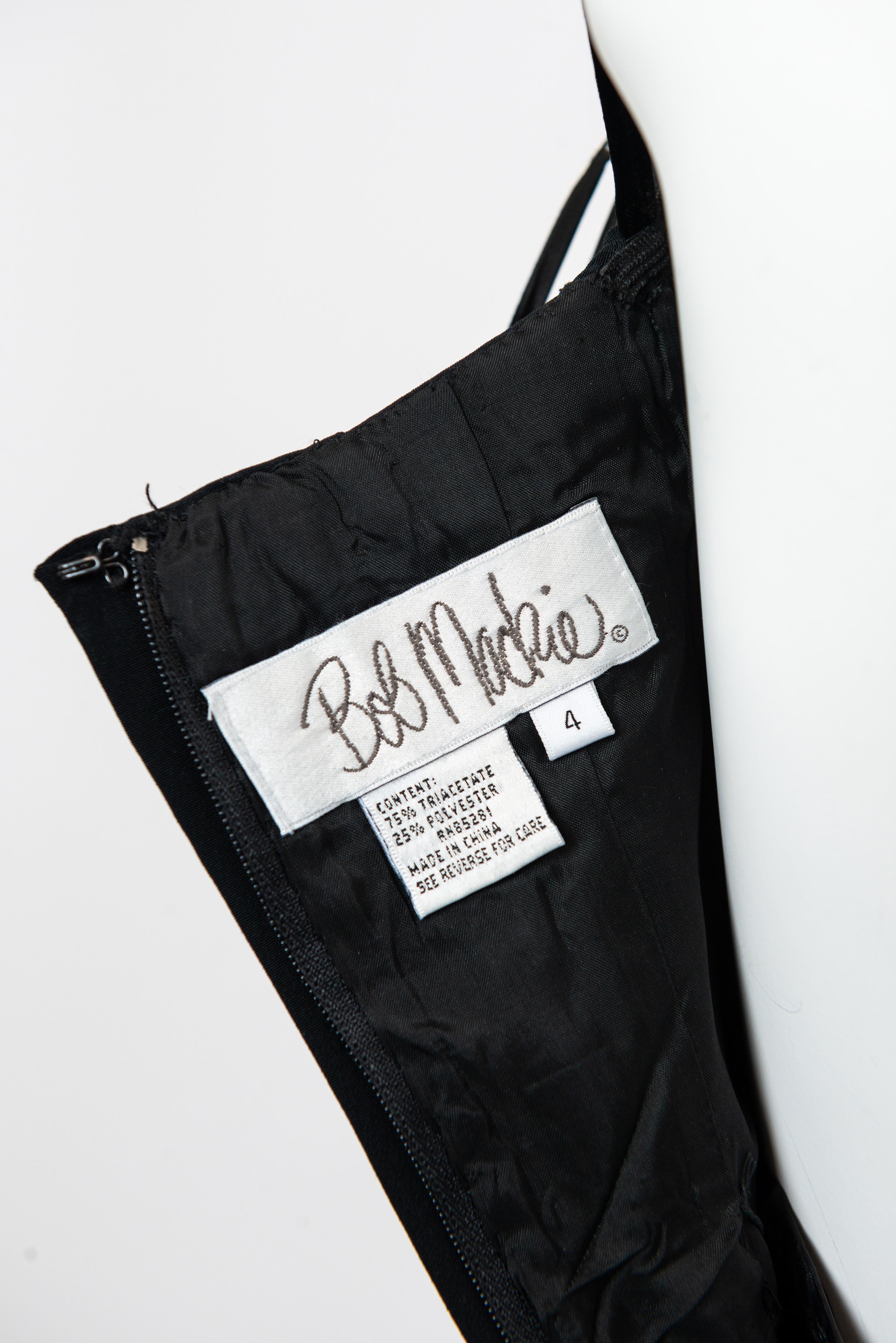 This stunning Bob Mackie black evening gown epitomizes 80s glamour with its luxurious velvet and intricate beaded trim detailing. The sophisticated silhouette demands drama—layer it beneath a structured overcoat or sumptuous fur for added elegance,