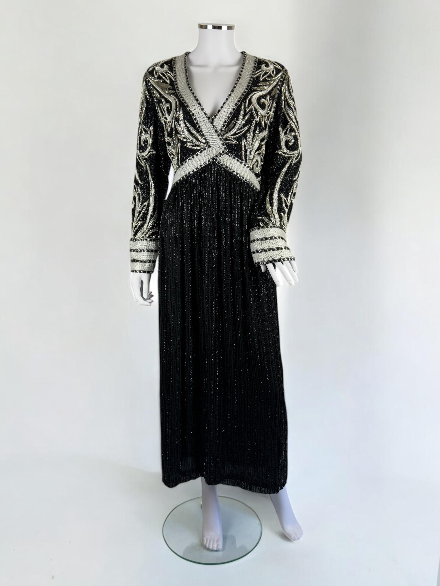 Dieses glamouröse, bodenlange Kleid von Bob Mackie aus den 1980er Jahren zeigt die für den Designer typische Opulenz und aufwändige Handwerkskunst. Das Kleid weist aufwändige silberne Perlen in wirbelnden, vom Art déco inspirierten Mustern über dem