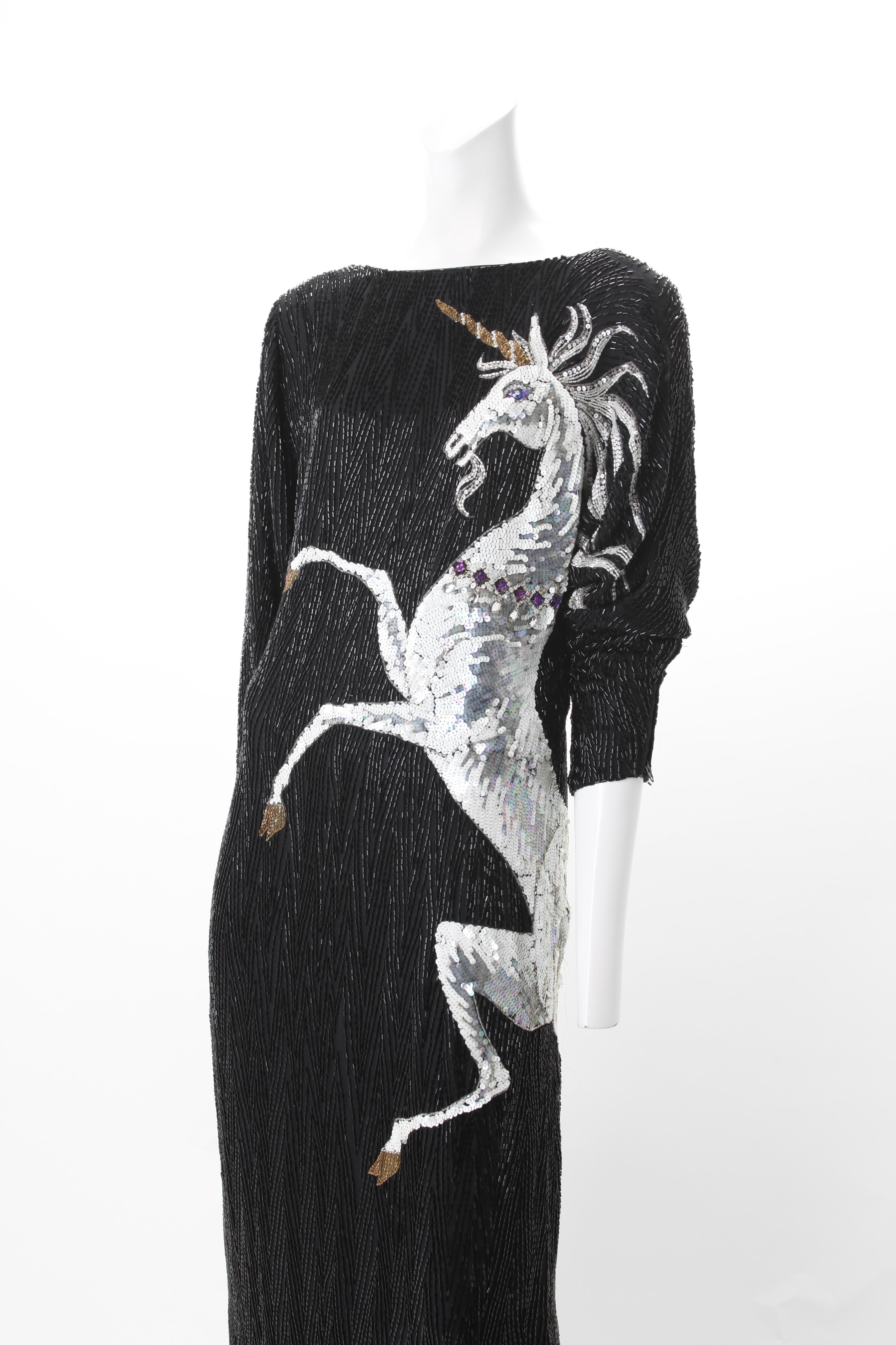 Bob Mackie Vintage Couture Black Silk Beaded Gown with Unicorn motif. c.1980s.
Boat neck gown with hand-sewn black beading throughout the entire dress. Silver and white Unicorn motif aligning the dress's left bodice continuing through to the back
