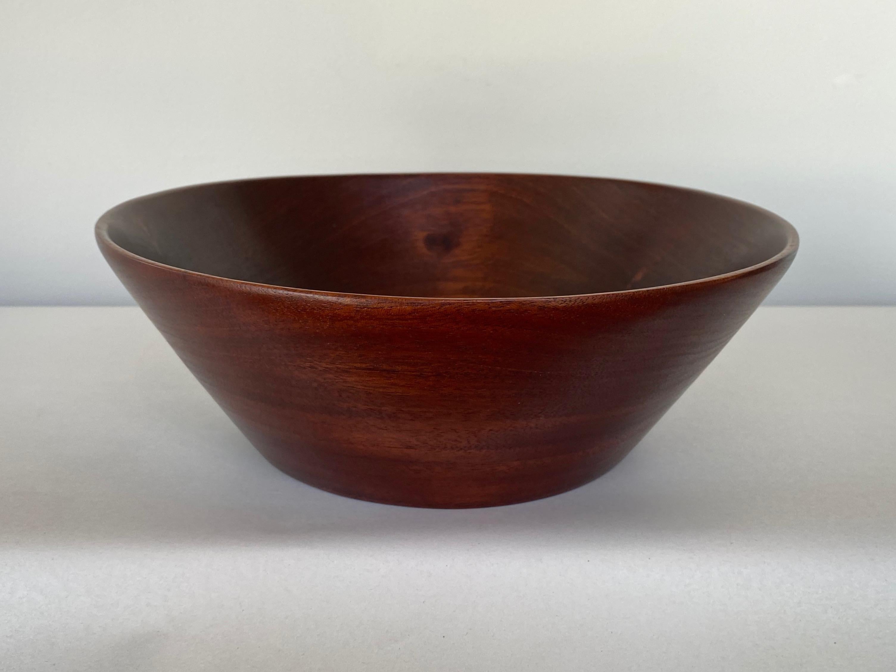 A 1960s mahogany turned wood bowl by important and influential American master woodturner Bob Stocksdale.

Deceptively simple lathe-turned solid mahogany form with straight exterior sides, smoothly curved interior, and thinly formed rim displays