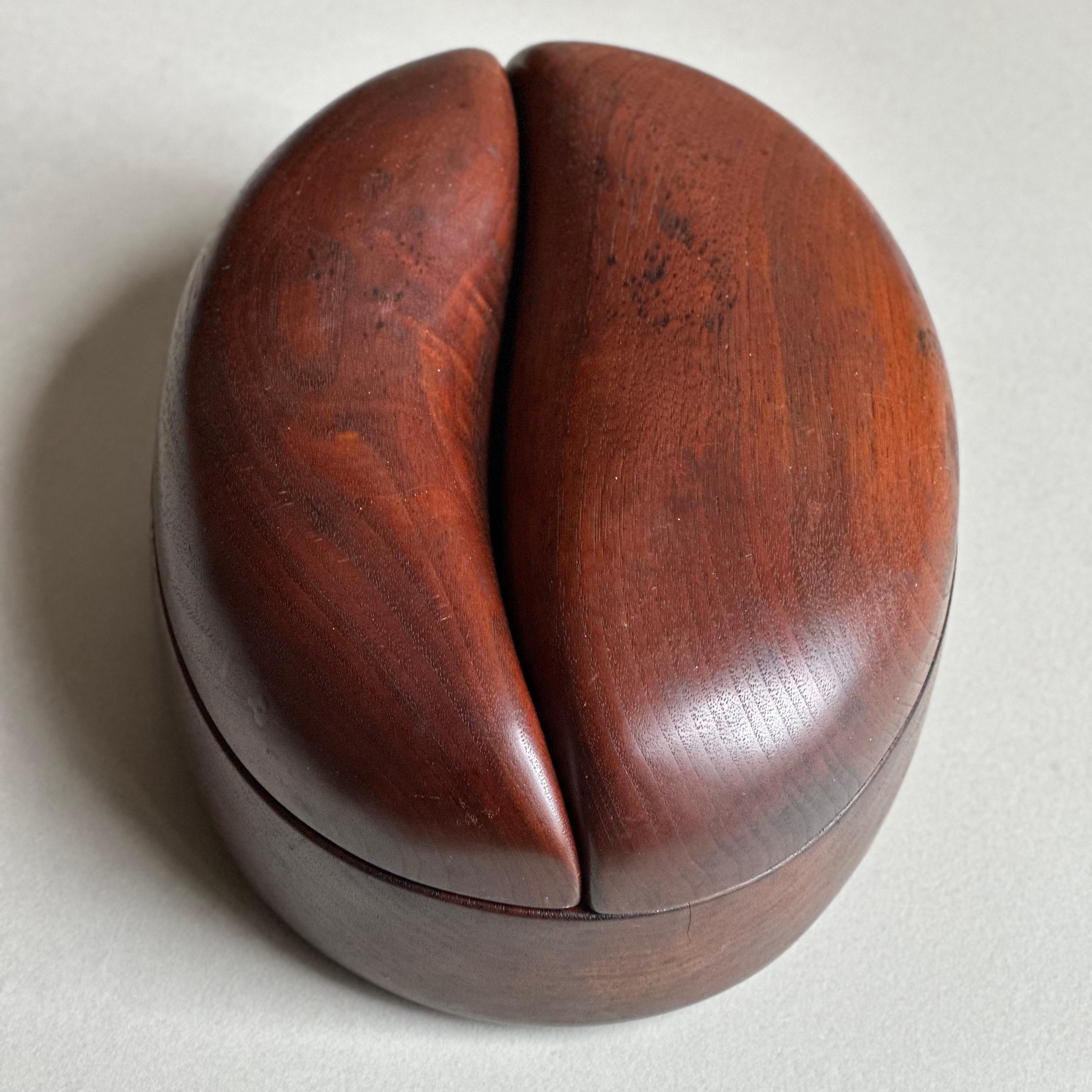 Boîte ovale très sculpturale avec une paire de couvercles yin-yang qui tournent en des points opposés, exécutée en noyer par Bobby Reed Falwell. Falwell a obtenu sa maîtrise en sculpture et en design de mobilier au RIT, où son conseiller pédagogique