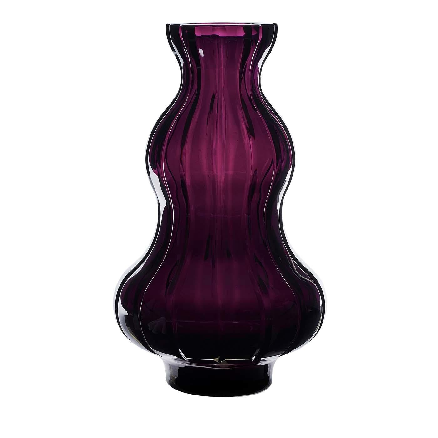A hymn to love and its sublime tensions, this vase was crafted of crystal with a deep amethyst color. The sinuous curves of its silhouette are enclosed in a transparent layer with vertical grooves that create a contrast and adds to the complexity of
