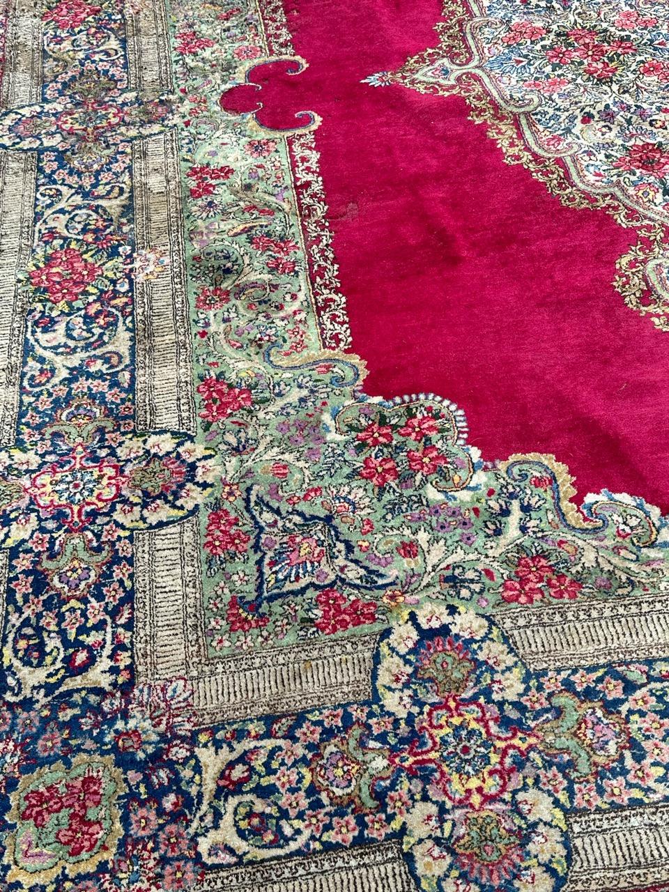 Large mid century Kirman rug with a beautiful floral design in the style of the savonnerie rugs and beautiful colours with a red on field, green, pink, red, yellow, blue, brown, purple and white. Many wears at different parts, due to the age and