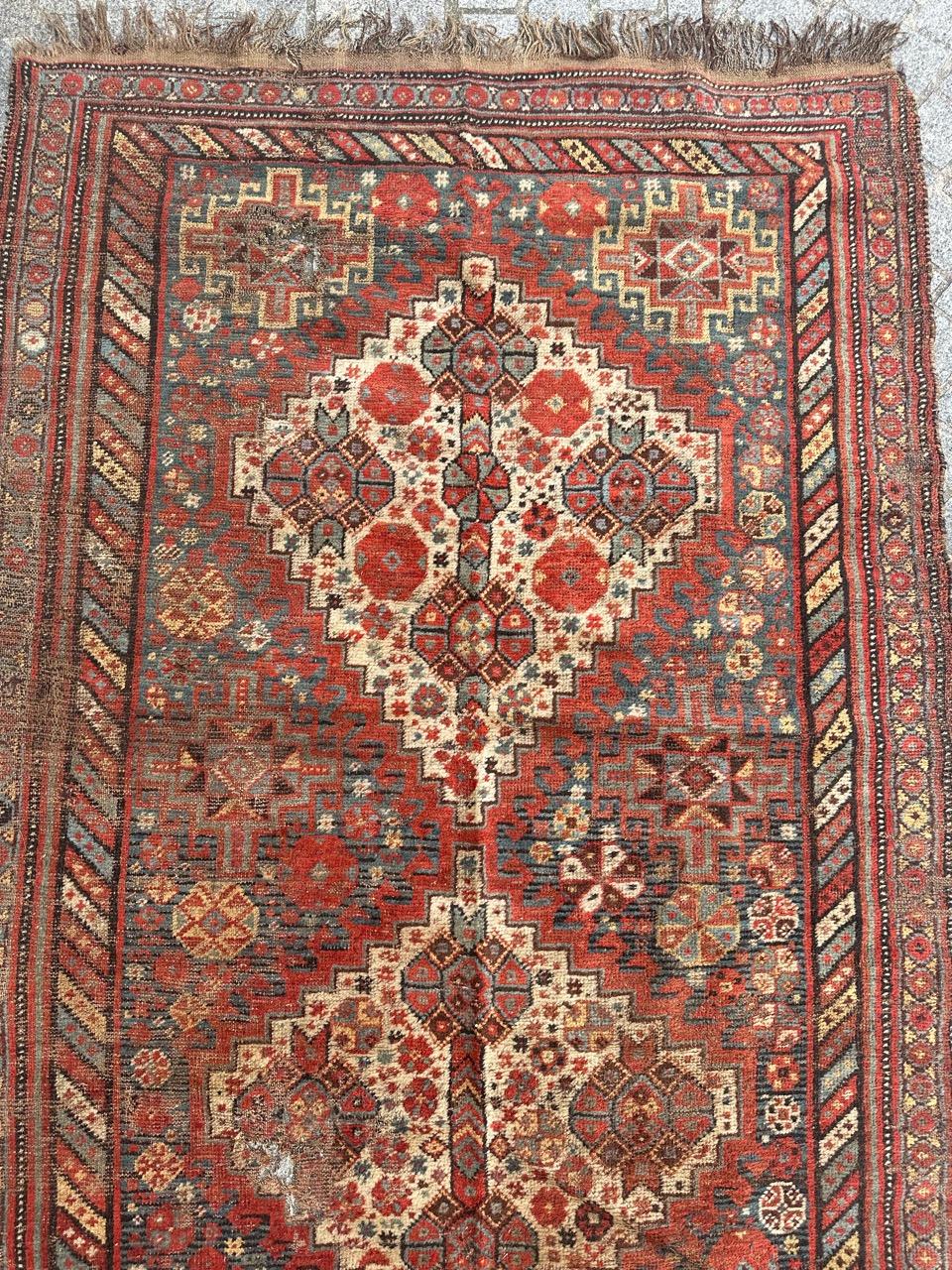 Beautiful late 19th century distressed Shiraz rug with a geometrical and tribal design with stylized designs, and nice natural colours with orange red, blue, yellow, white and black. Many wears , some damages and small missing at one edge. Entirely