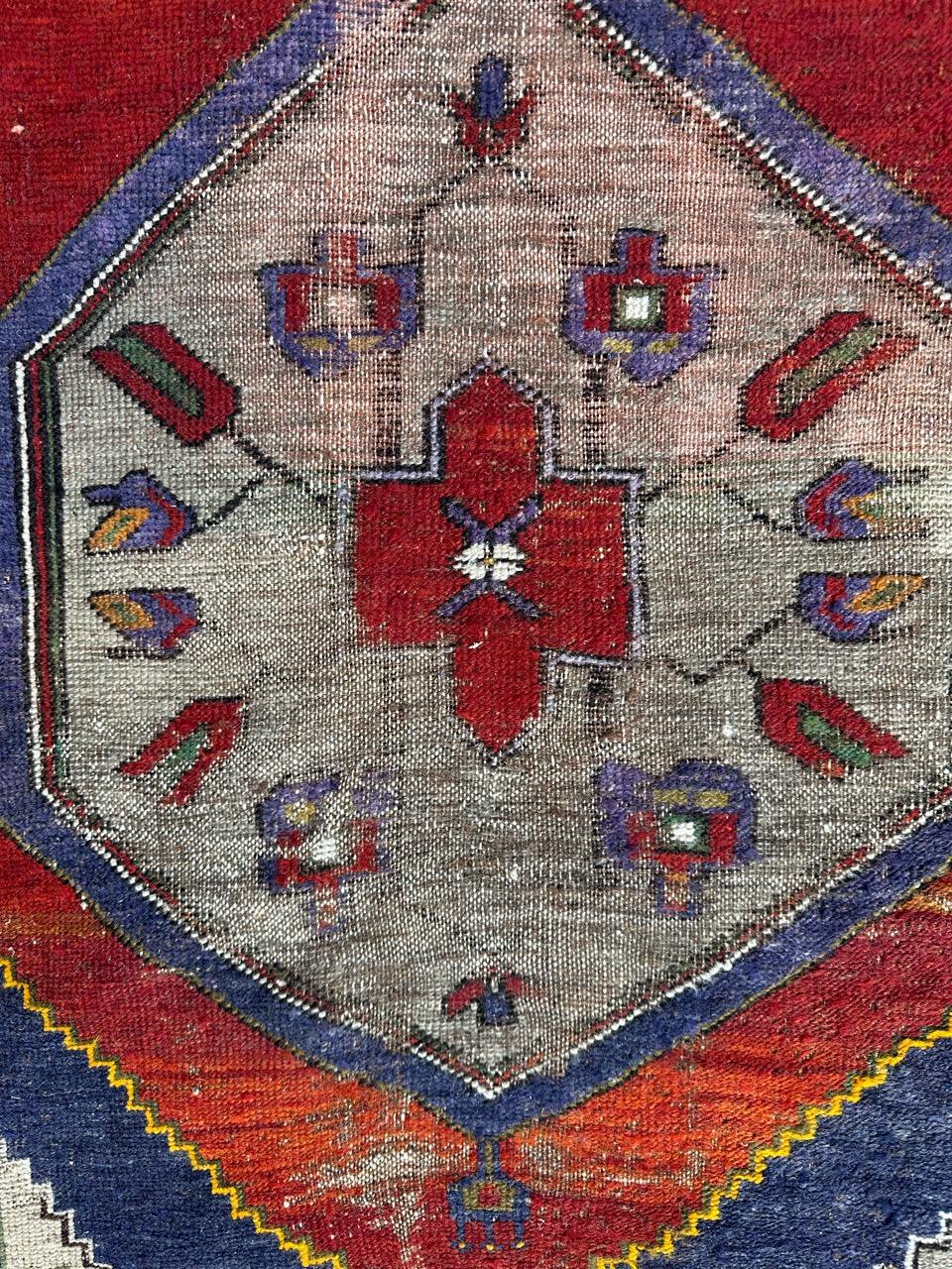 Pretty early 20th century Turkish Anatolian rug with nice geometrical and stylized designs and beautiful natural colours, with red, blue, purple, green and orange. Entirely hand knotted with wool on wool foundation. Important wears and some damages.