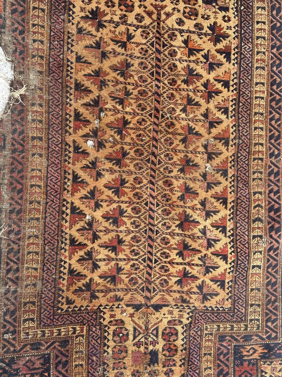 Beautiful antique distressed tribal collectible Baluch rug with a tribal and stylized designs, and nice natural colours with yellow background, orange, purple, pink and navy blue, entirely and very finely hand knotted with wool on wool foundation.