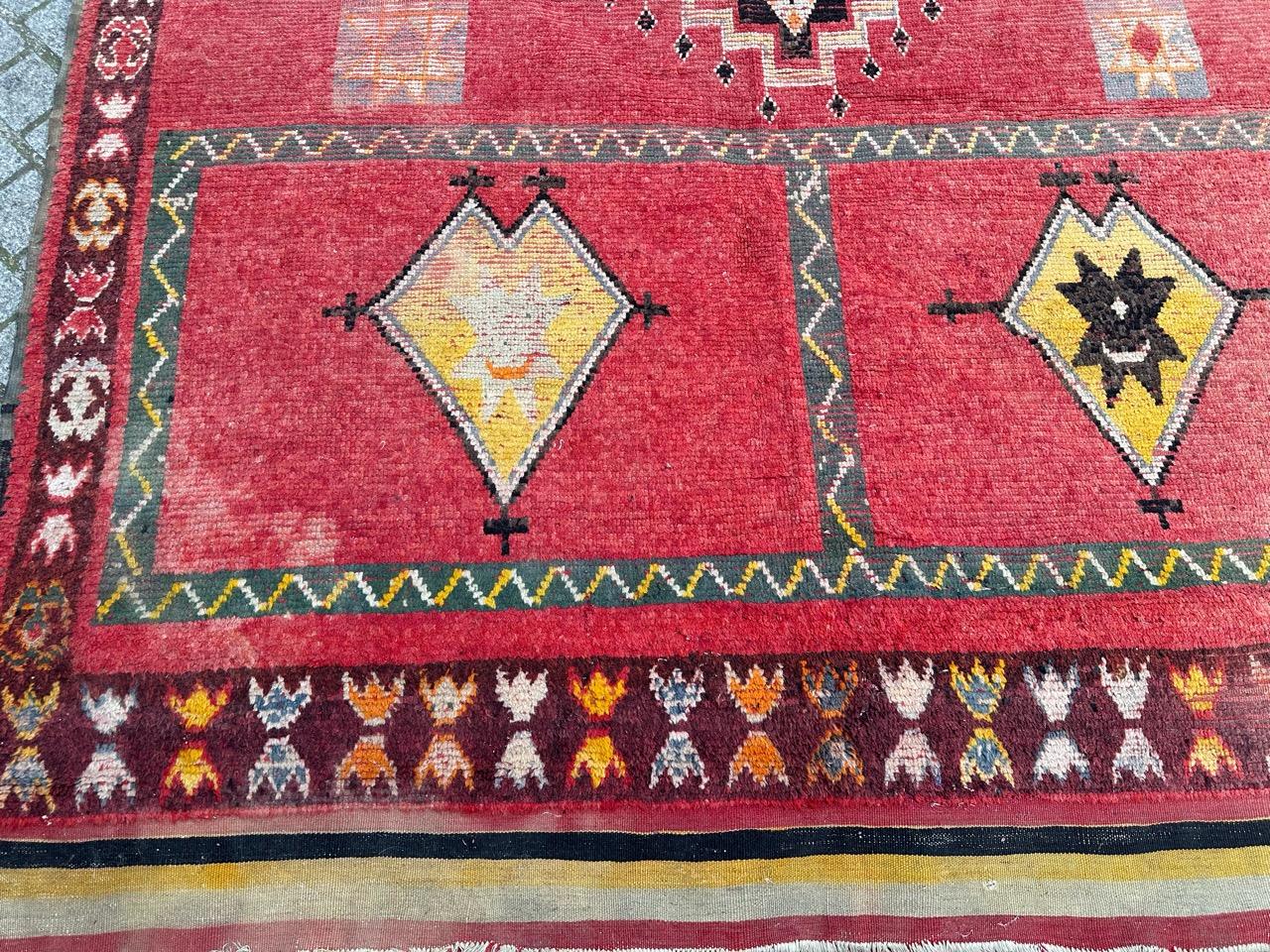 Beautiful mid century tribal Moroccan Berber rug with nice geometrical design and beautiful colours with a red color on the field and black, grey and yellow on the design, wears due to the age and use. Little damages at extremities .entirely hand