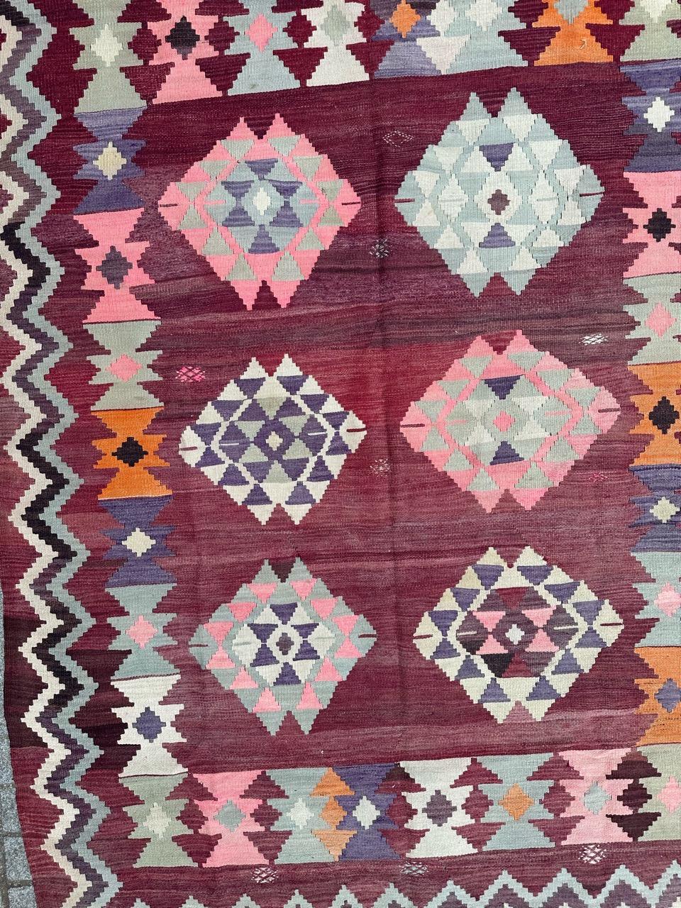 Nice vintage Turkish Anatolian Kilim with a beautiful geometrical and tribal design and nice colours with a purple and pink colours in the field, pink. Blue, green, brown, orange and white in design, entirely hand woven with wool on wool