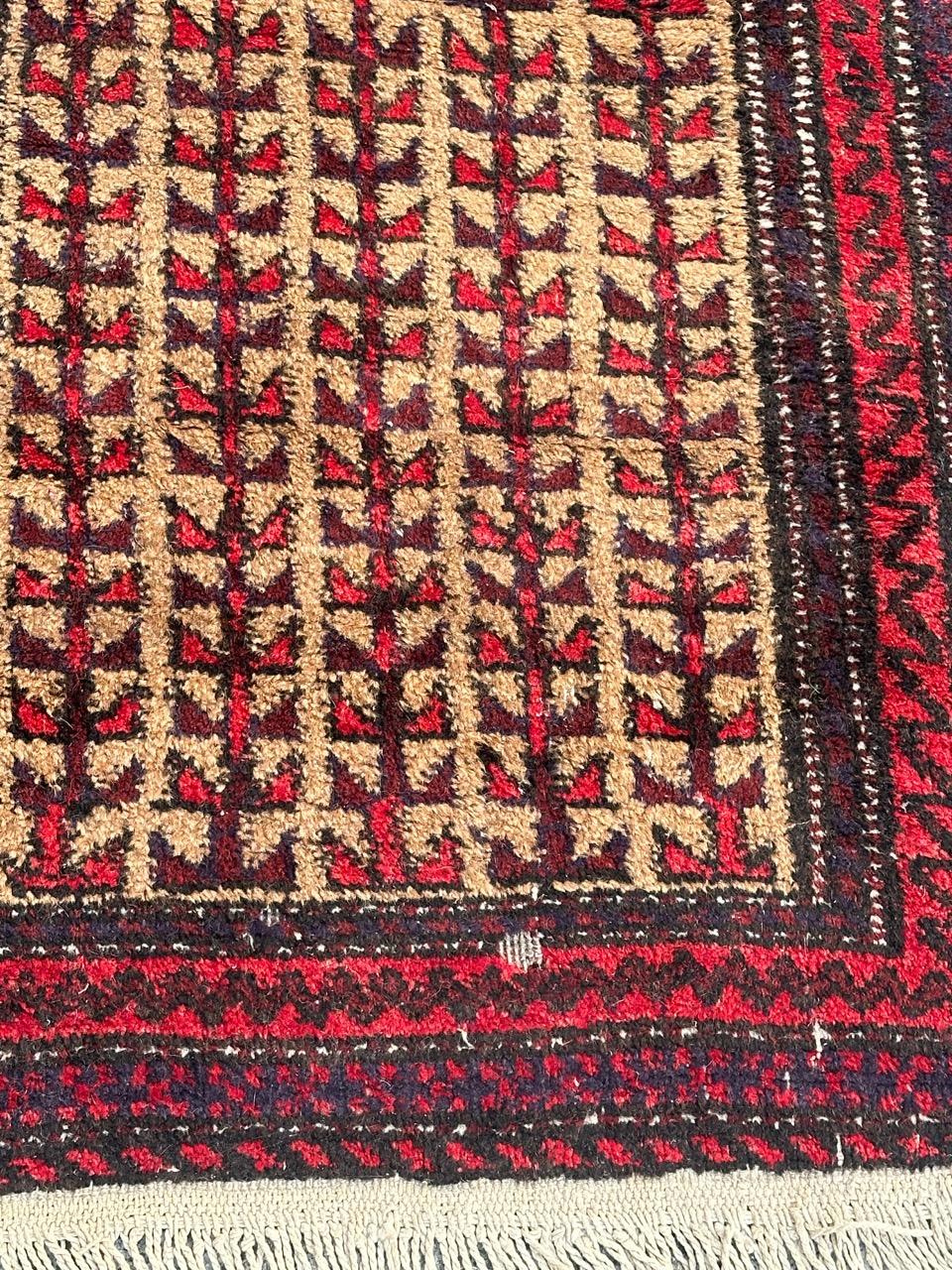 Grazioso tappeto Baluch turkmeno di metà secolo con disegni stilizzati e bei colori con campo giallo, rosso, marrone, viola, bianco e nero, interamente annodato a mano con lana su base di cotone.
Alcuni segni di usura dovuti all'età e