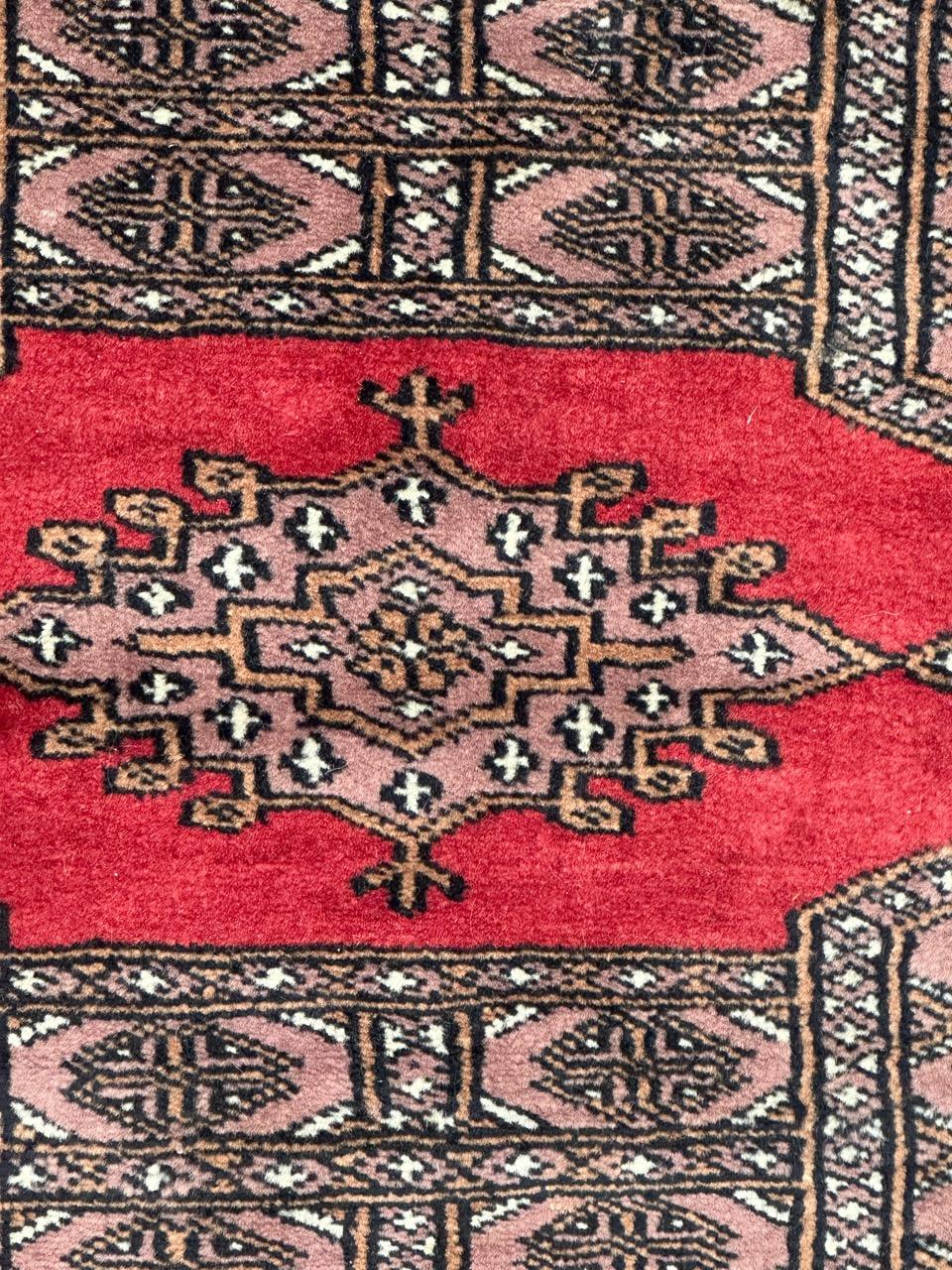 Magnifique tapis pakistanais vintage avec un design des tapis turkmènes et de belles couleurs avec du rouge, du rose, du gris, du jaune, du blanc et du noir, entièrement et finement noué à la main avec de la laine sur une base de coton.